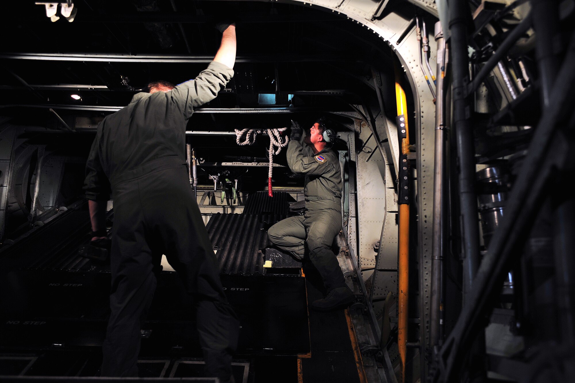 U.S. Air Force Staff Sgt. Ronnie Bitten (left) and Senior Airmen Andy Espinosa (right), 41st Electronic Combat Squadron, are in the back of an EC-130H performing their preflight checks on Davis-Monthan Air Force Base, Ariz., Oct 15, 2012. The 41st ECS was activated at D-M in July 1980. (U.S. Air Force photo by Airman 1st Class Josh Slavin/Released)
