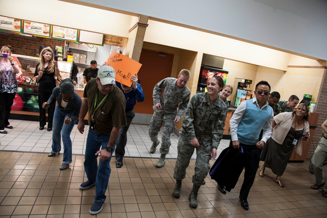 Members of the Energy Action Month Flash Mob dance together at the Laughlin Air Force Base Exchange Oct. 18, 2012. The Air Force’s Energy Action Month is designed to teach the need to reduce energy demands, increasing energy supply through conservation and change cultural views on energy use. (U.S. Air Force photo/Airman 1st Class Nathan Maysonet)