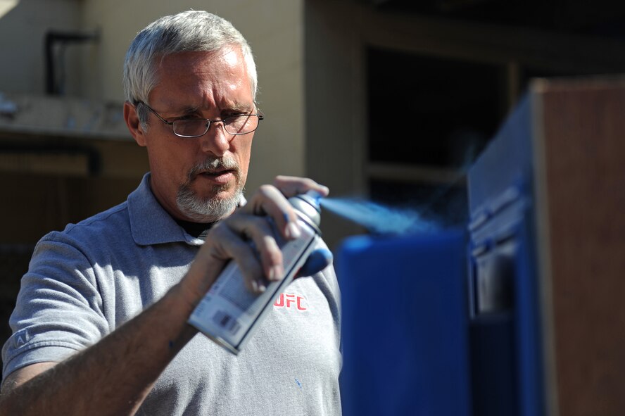 Tony Flowers, 2nd Force Support Squadron Barksdale Club general manager, spray paints a detachable piece of a custom built entertainment center for the upcoming Game-Tastic Fest in the Stripes Club on Barksdale Air Force Base, La., Oct. 19. Game-Tastic Fest is a two-day video game competition that will feature some of the latest first-person shooter videogames. Two competitions will be held, one for youths ages eight to 17 years old and one for adults 18 years and up. The winning team will receive $300, with second and third place teams taking home $200 and $100, respectively. (U.S. Air Force photo/Senior Airman Micaiah Anthony)(RELEASED)