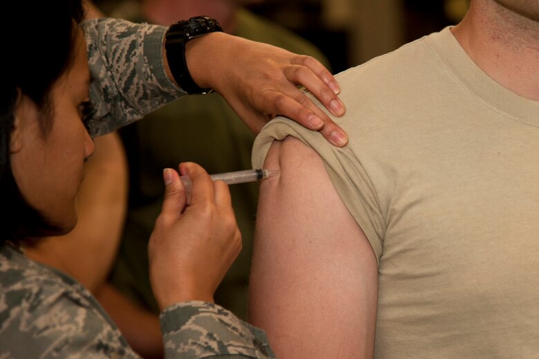 VANDENBERG AIR FORCE BASE, Calif. – – A 30th Medical Group technician administers the flu vaccine to an active duty Airman at the Point of Distribution (POD) in the Installation Deployment Readiness Cell here Thursday, Oct. 18, 2012. Active duty Airmen reported to the POD in an exercise simulating mass immunization against anthrax, and base authorities used the opportunity to distribute this year’s real world influenza vaccine.  The POD distributed Skittles candy representing the anthrax prophylaxis to over 1,900 Airmen and then vaccinated over 1,500 Airmen for influenza, raising the wing’s flu vaccination rate to over 90%.  The purpose of the exercise was toevaluate the wing’s response to a public health emergency by testing the 30th Medical Group’s ability to stand up a POD and rapidly distribute countermeasures. Mass inoculation of this scale was a first for Vandenberg Air Force Base. (U.S. Air Force photo/Senior Airman Lael Huss)