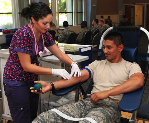 Valorie Guerra, Blood Source phlebotomist, takes a blood donation from Airman Basic Raymond Rubio, 372th Training Squadron crew chief student, at the Beale Air Force Base, Calif. community activity center Oct. 19, 2012. Blood donations provide life-saving treatments to accident victims, surgery patients, cancer patients and many others in need of a transfusion. (U.S. Air Force photo by Senior Airman Allen Pollard)