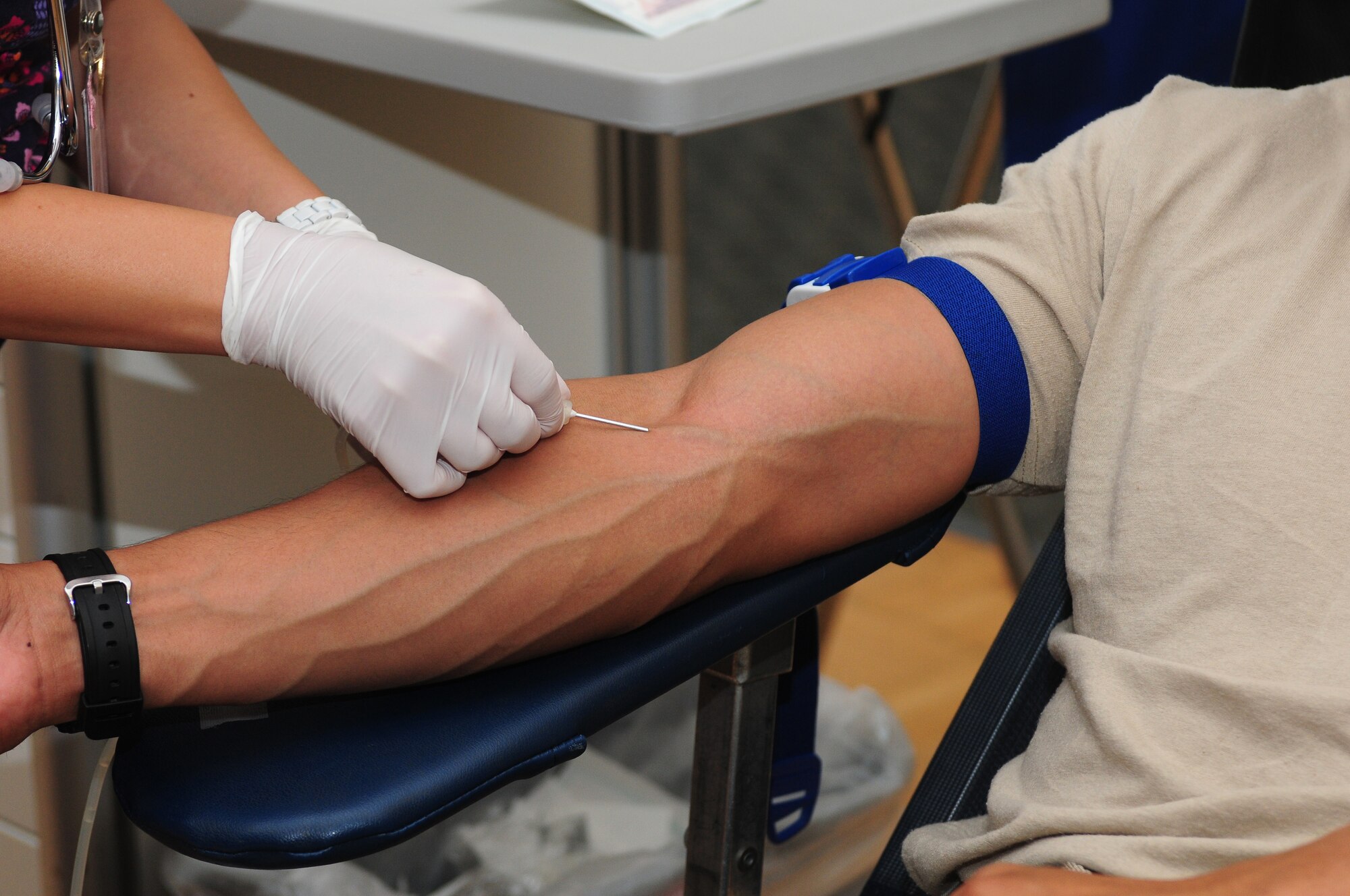 Valorie Guerra, Blood Source phlebotomist, inserts a needle during a blood donation from Airman Basic Raymond Rubio, 372th Training Squadron crew chief student, at the Beale Air Force Base, Calif. community activity center Oct. 19, 2012. Blood Source sends donations to more than 40 hospitals in 25 different countries. (U.S. Air Force photo by Senior Airman Allen Pollard)