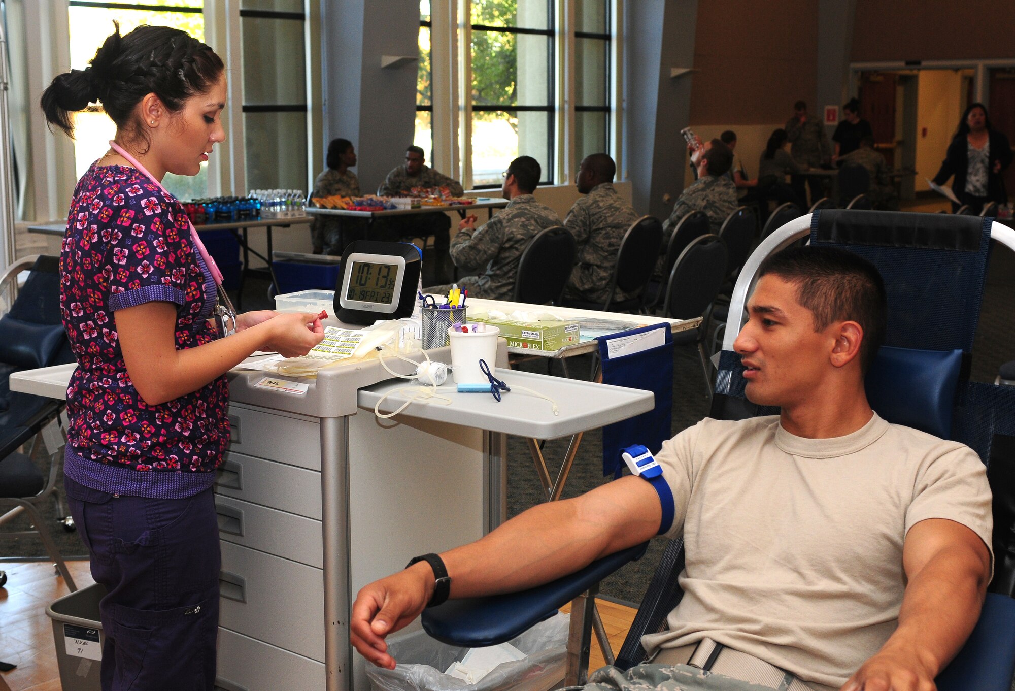 Valorie Guerra, Blood Source phlebotomist, preps for a blood donation from Airman Basic Raymond Rubio, 372th Training Squadron crew chief student, at the Beale Air Force Base, Calif. community activity center Oct. 19, 2012. Each donation of blood has the ability to save up to three lives. (U.S. Air Force photo by Senior Airman Allen Pollard)