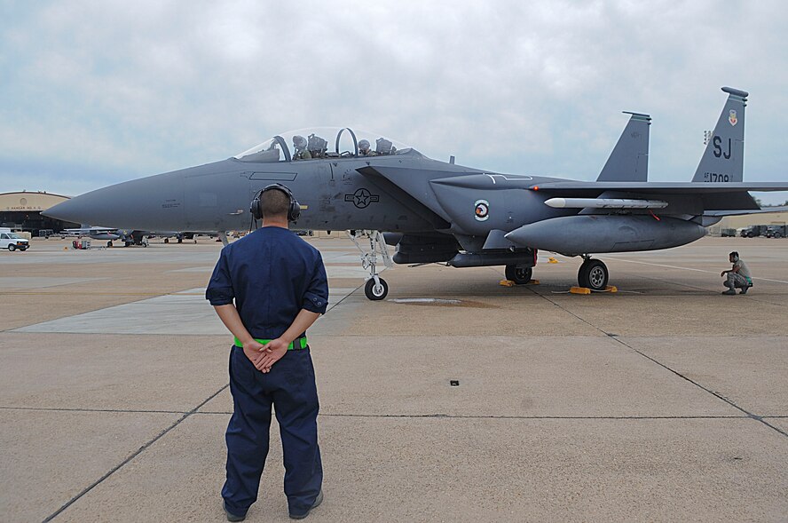 Senior Airman Lawrence McGregor, aircraft maintenance unit crew chief and Airman 1st Class Travis Vinluan, AMU avionics technician, both with the 335th Fighter Squadron, Seymour Johnson Air Force Base, N.C., wait for a signal during a pre-launch inspection on Barksdale Air Force Base, La., Oct. 16. More than 160 Airmen and 12 F-15E Strike Eagles from Seymour Johnson are at Barksdale for joint training with the 82nd Airborne Division, Fort Bragg, N.C., during Green Flag East. (U.S. Air Force photo/Senior Airman Kristin High)(RELEASED)
