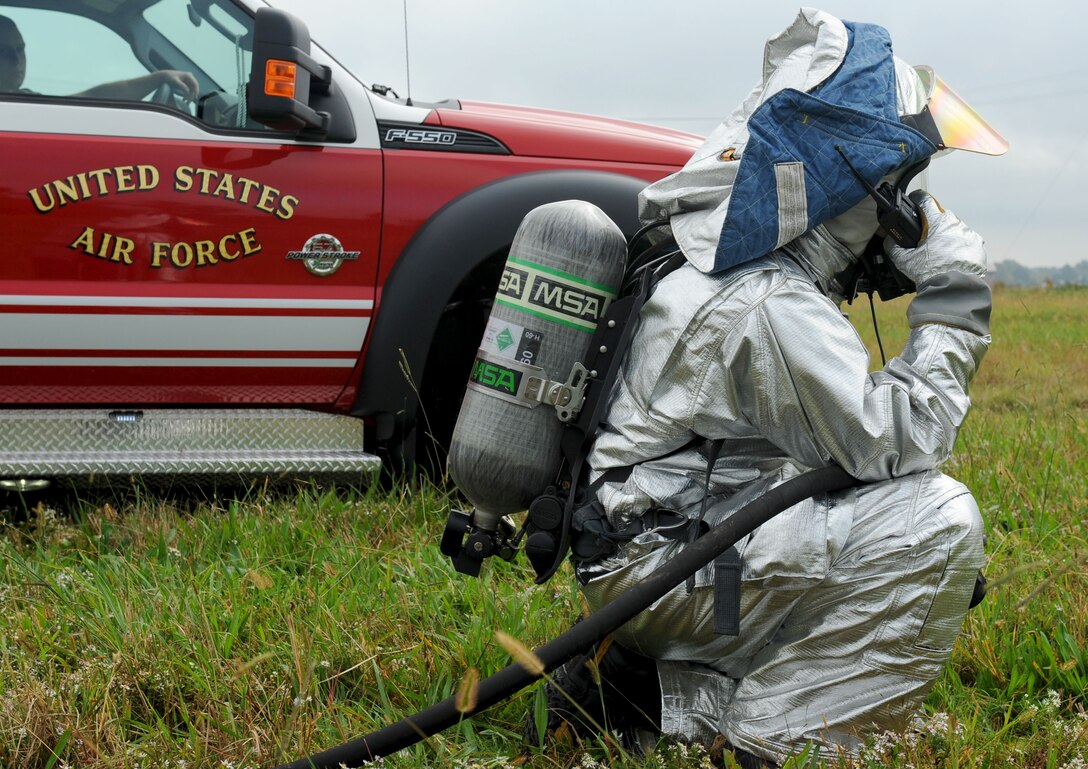 U.S. Air Force Staff Sgt. Derek Dobbins, 633rd Civil Engineer Squadron firefighter, listens to radio commands during a major accident response exercise at Langley Air Force Base, Va., Oct. 19, 2012. The firefighters were the first on the scene to put out the simulated fire, search for and recover any casualties. (U.S. Air Force photo by Staff Sgt. Ashley Hawkins/Released)
