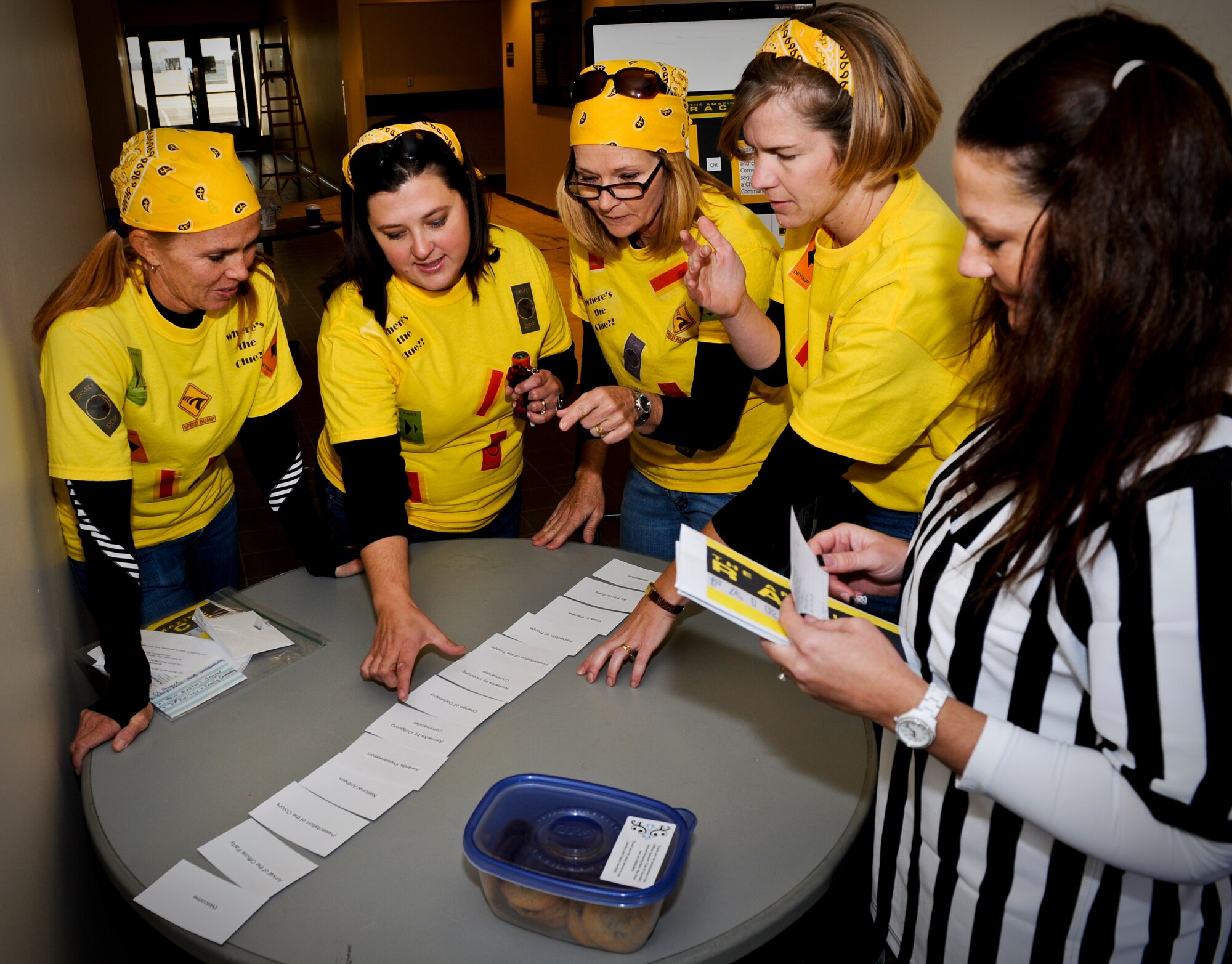Fairchild spouses from team "The Bees" figure out clues to advance to their next location as Autumn O'Brien, wife of Lt. Col. Patrick O'Brien, the 93rd Air Refueling Squadron commander, monitors their progress at Fairchild Air Force Base, Wash., Oct. 18, 2012. The event, named after the popular television show, "Amazing Race," afforded spouses an opportunity to show their support for Fairchild's Airmen as they delivered gift certificates and cookies at each clue stop along the way. The teams consisted of spouses from many of the squadrons on base. (U.S. Air Force photo by Senior Airman Benjamin Stratton)