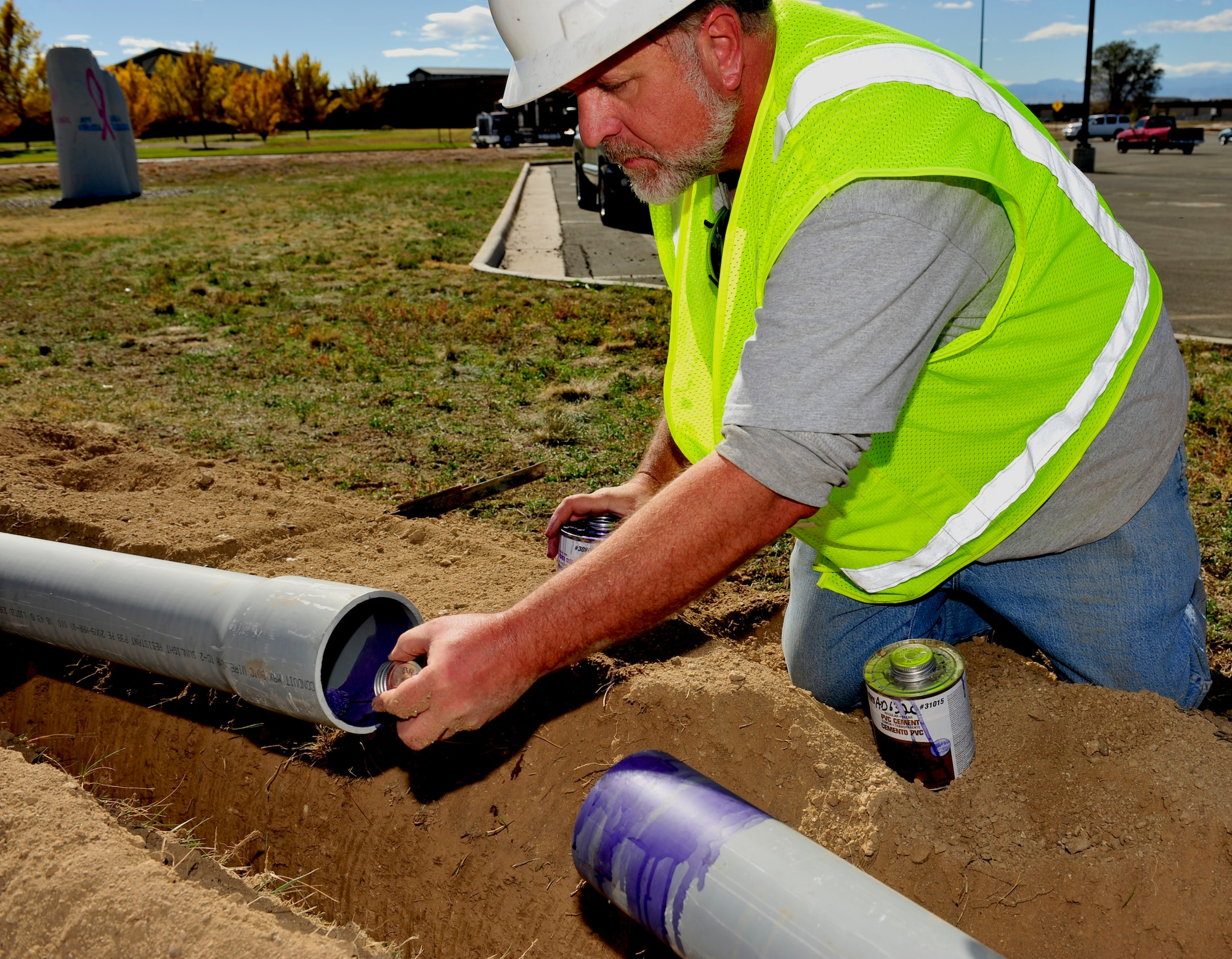 BUCKLEY AIR FORCE BASE, Colo.– Jerald Gilkey, 460th Civil Engineer Squadron high voltage electrician, spreads polyvinyl chloride cement to connect two pipes containing electrical wiring Oct. 16, 2012. Electrical wiring is run underground so lighting can be installed as part of ongoing quality-of-life projects around base. (U.S. Air Force photo by Airman 1st Class Darryl Bolden Jr.)