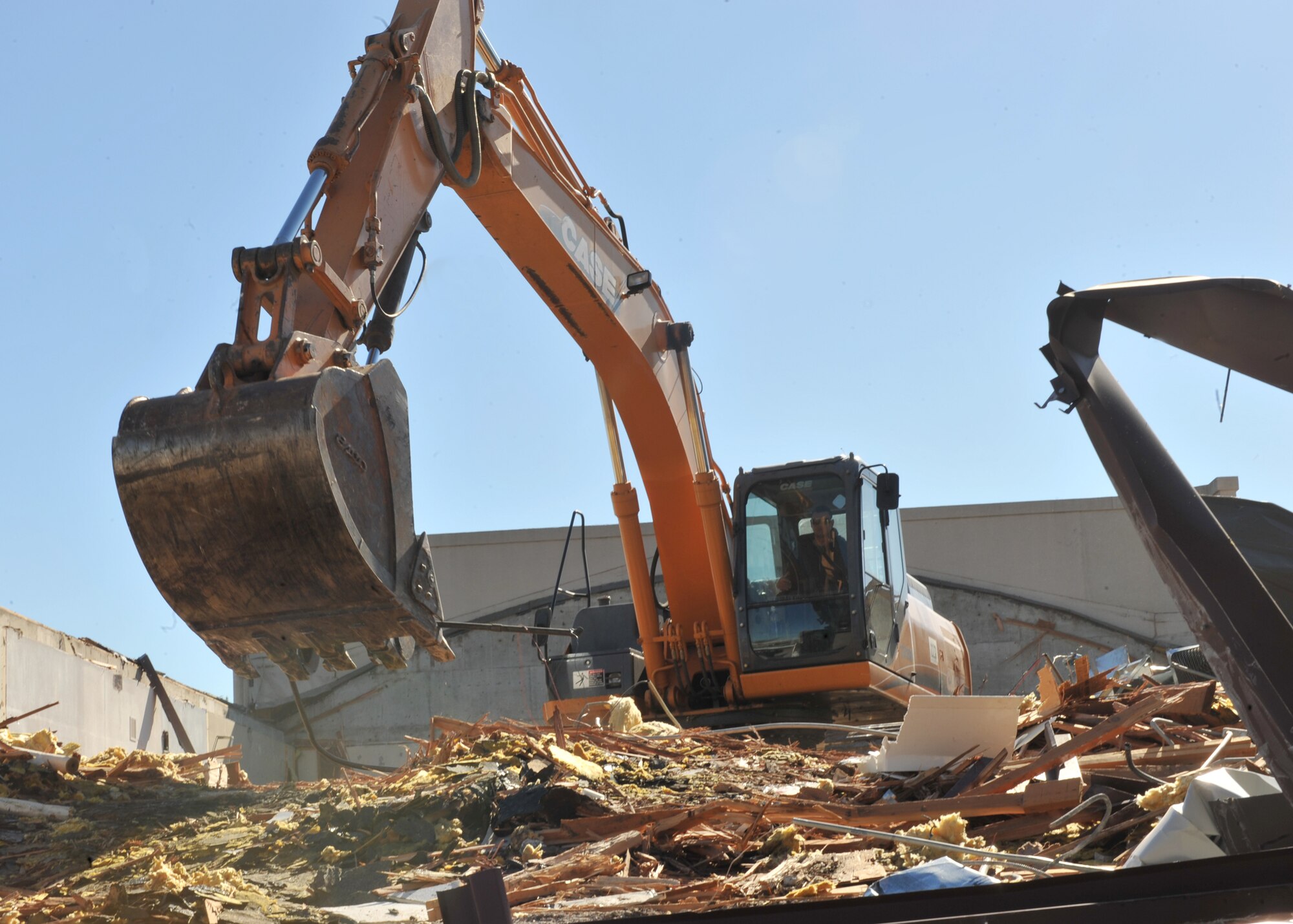 An excavator demolishes Building 804 Oct. 19, 2012, McConnell Air Force Base, Kan. The removal of Building 804, along with other structures on base, is part of the Air Force’s goal to become more efficient and reduce energy costs by 20 perscent by the year 2020. (U.S. Air Force photo/Airman 1st Class Maurice A. Hodges)