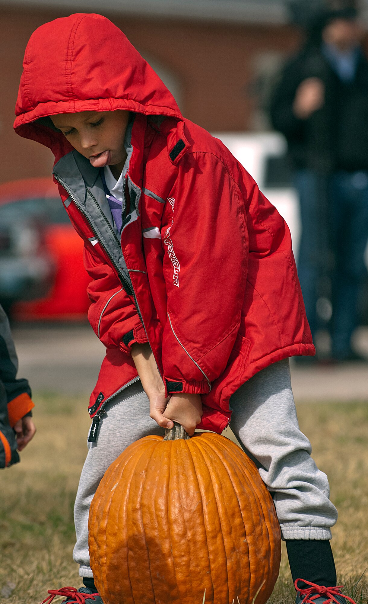 Jadyn Gomes, 7, struggles to lift the pumpkin he picked out at a Fire Prevention Week open house and fall festival co-sponsored by the 90th Civil Engineer Squadron and Balfour Beatty Communities Oct. 13. Gomes attended the event at Fire Station 1 on F. E. Warren Air Force Base, Wyo., with his parents, Brittany and Staff Sgt. David Gomes, 20th Air Force. (U.S. Air Force photo by R.J. Oriez)