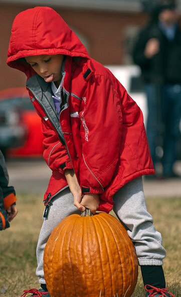 Jadyn Gomes, 7, struggles to lift the pumpkin he picked out at a Fire Prevention Week open house and fall festival co-sponsored by the 90th Civil Engineer Squadron and Balfour Beatty Communities Oct. 13. Gomes attended the event at Fire Station 1 on F. E. Warren Air Force Base, Wyo., with his parents, Brittany and Staff Sgt. David Gomes, 20th Air Force. (U.S. Air Force photo by R.J. Oriez)