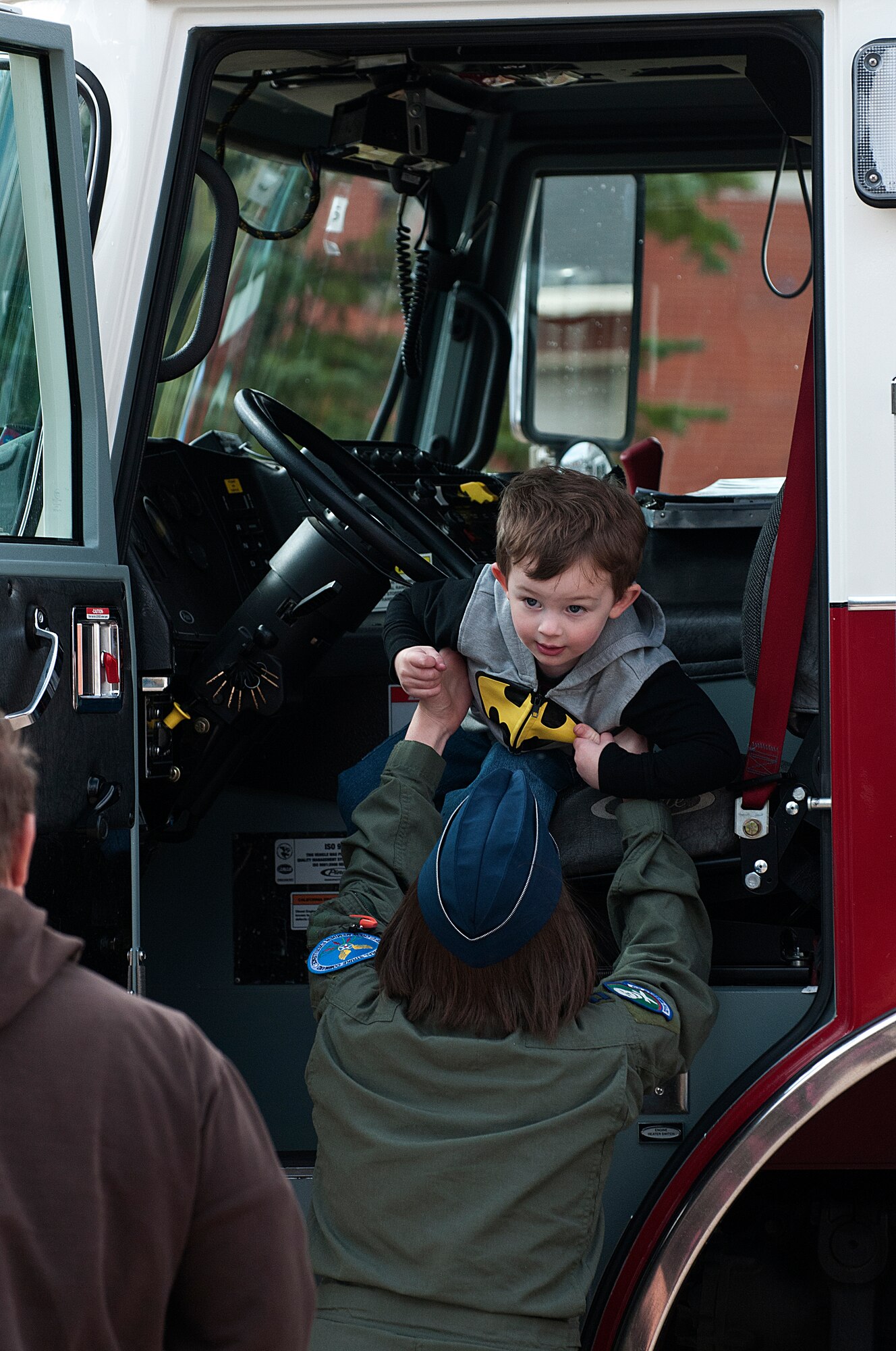 Jason Daniel, 3, is helped down out of the cab of a fire truck by his mother, Capt. Rachel Daniel, 321st Missile Squadron, Oct. 13. The Daniels attended a Fire Prevention Week open house and fall festival co-sponsored by the 90th Civil Engineer Squadron and Balfour Beatty Communities on F. E. Warren Air Force Base, Wyo. (U.S. Air Force photo by R.J. Oriez)