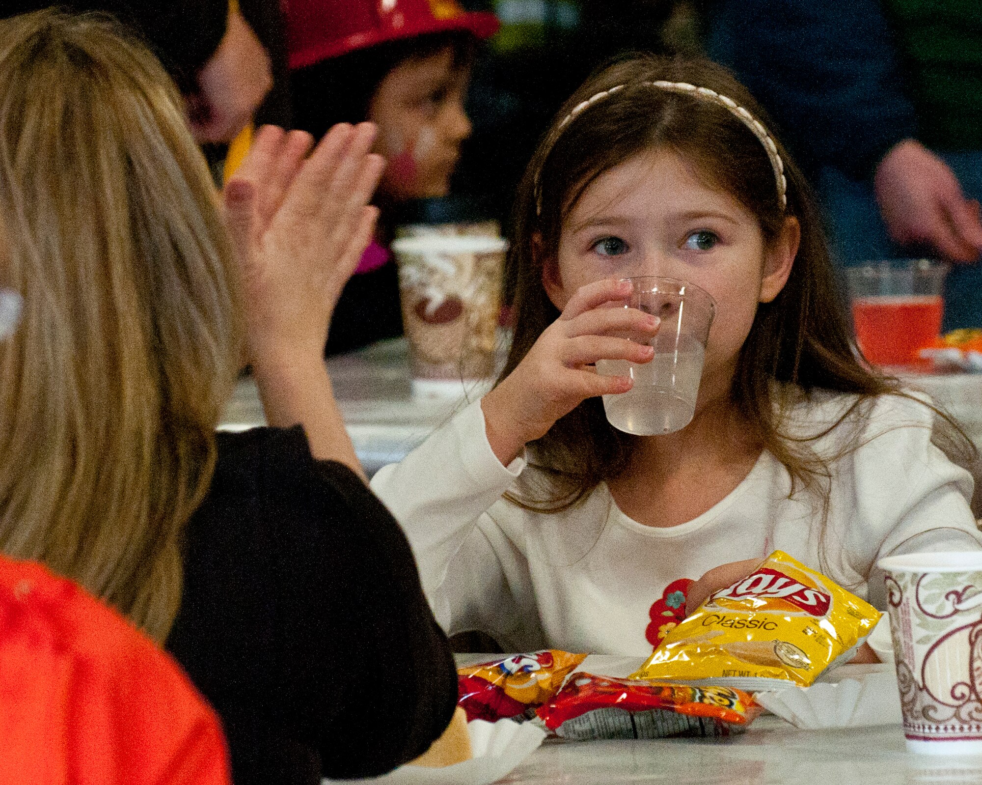 Audrey Baker, 8, takes part in some of the refreshments provided by the 90th Civil Engineer Squadron and Balfour Beatty Communities during a Fire Prevention Week open house and fall festival at Fire Station on F. E. Warren Air Force Base, Wyo., Oct. 13. Baker is the daughter of Capt. Jason Baker, 30th Airlift Squadron, and attended the event with her mother, Jeannie Baker, left. . (U.S. Air Force photo by R.J. Oriez)