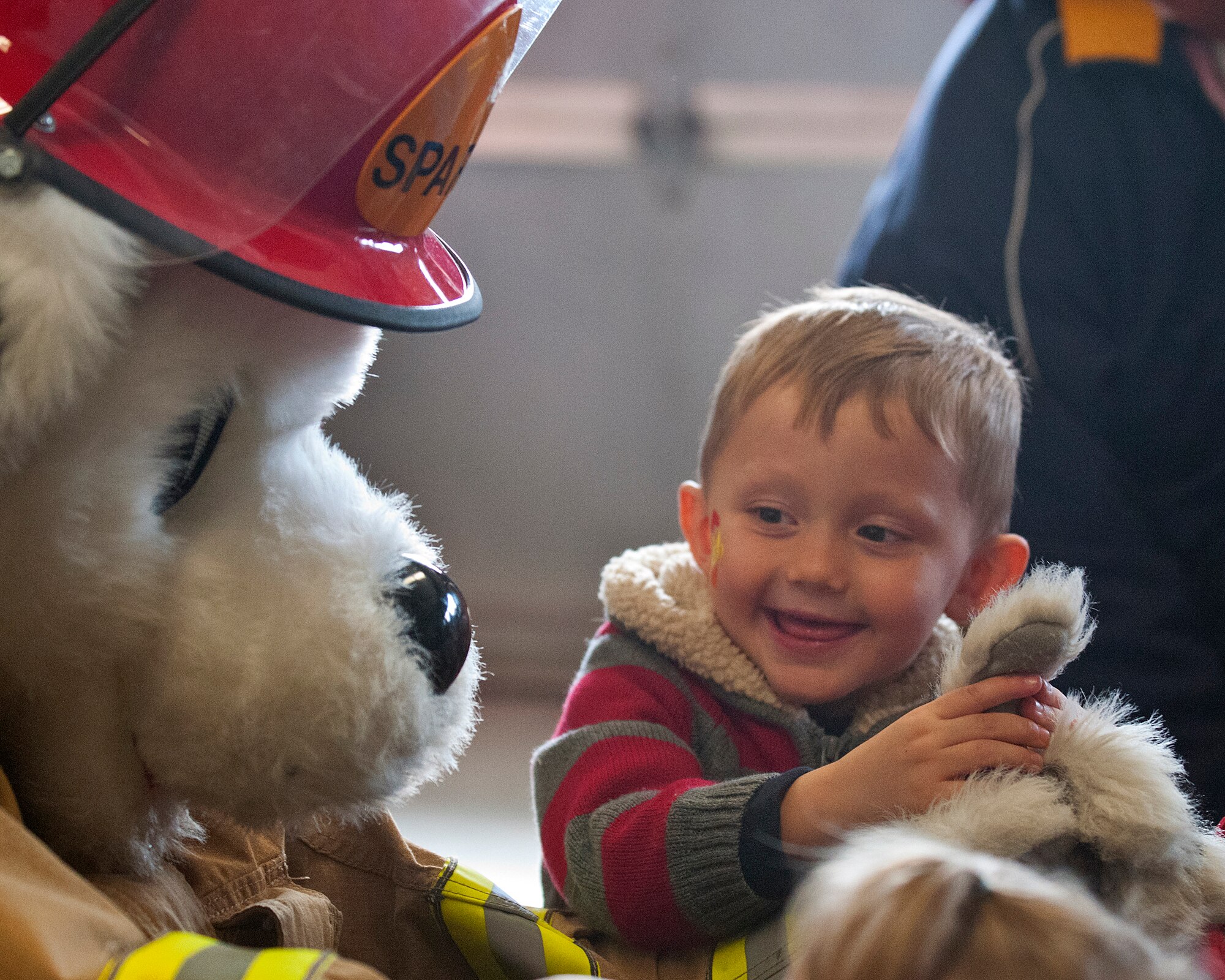 Anthony Hull, 4, plays with the paw of Sparky during a puppet show at F. E. Warren Air Force Base Fire Station Oct. 13 during a Fire Prevention Week open house and fall festival co-sponsored by the 90th Civil Engineer Squadron and Balfour Beatty Communities. Hull is the son of Andrea and Army Staff Sgt. Jason Hull, Wyoming National Guard. (U.S. Air Force photo by R.J. Oriez)