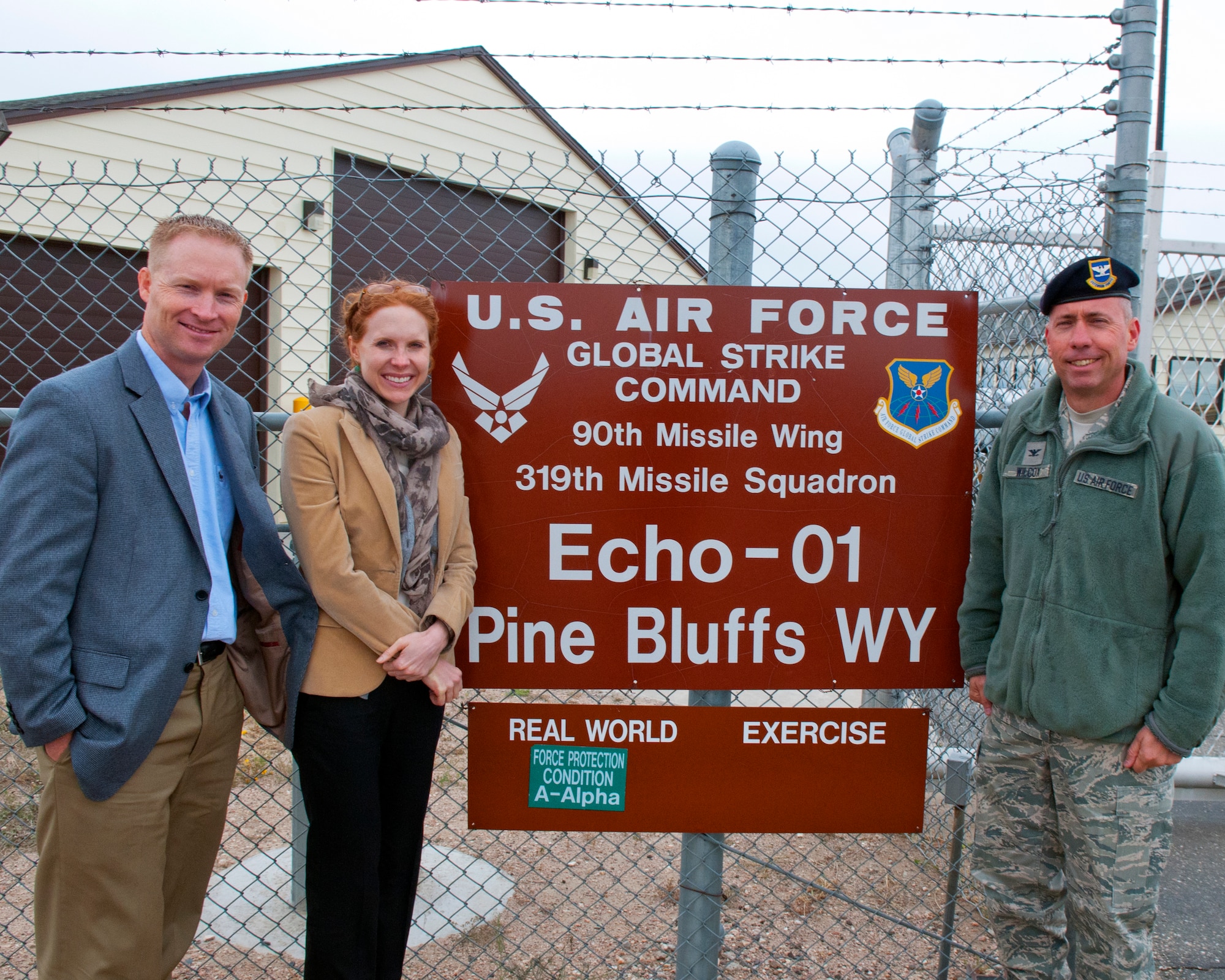 Air Force Maj. Jason Jensen, congressional appropriations liaison, and Karen Courington, Senate Appropriations Committee defense staff member, pose with Col. Tom Wilcox, 90th Security Forces Group commander, outside the gate of Missile Alert Facility E-01 near Pine Bluffs, Wyo., Oct. 9. Courington toured the MAF as part of a visit to the 90th Missile Wing and F.E. Warren Air Force Base, Wyo. (U.S. Air Force photo by R.J. Oriez)


