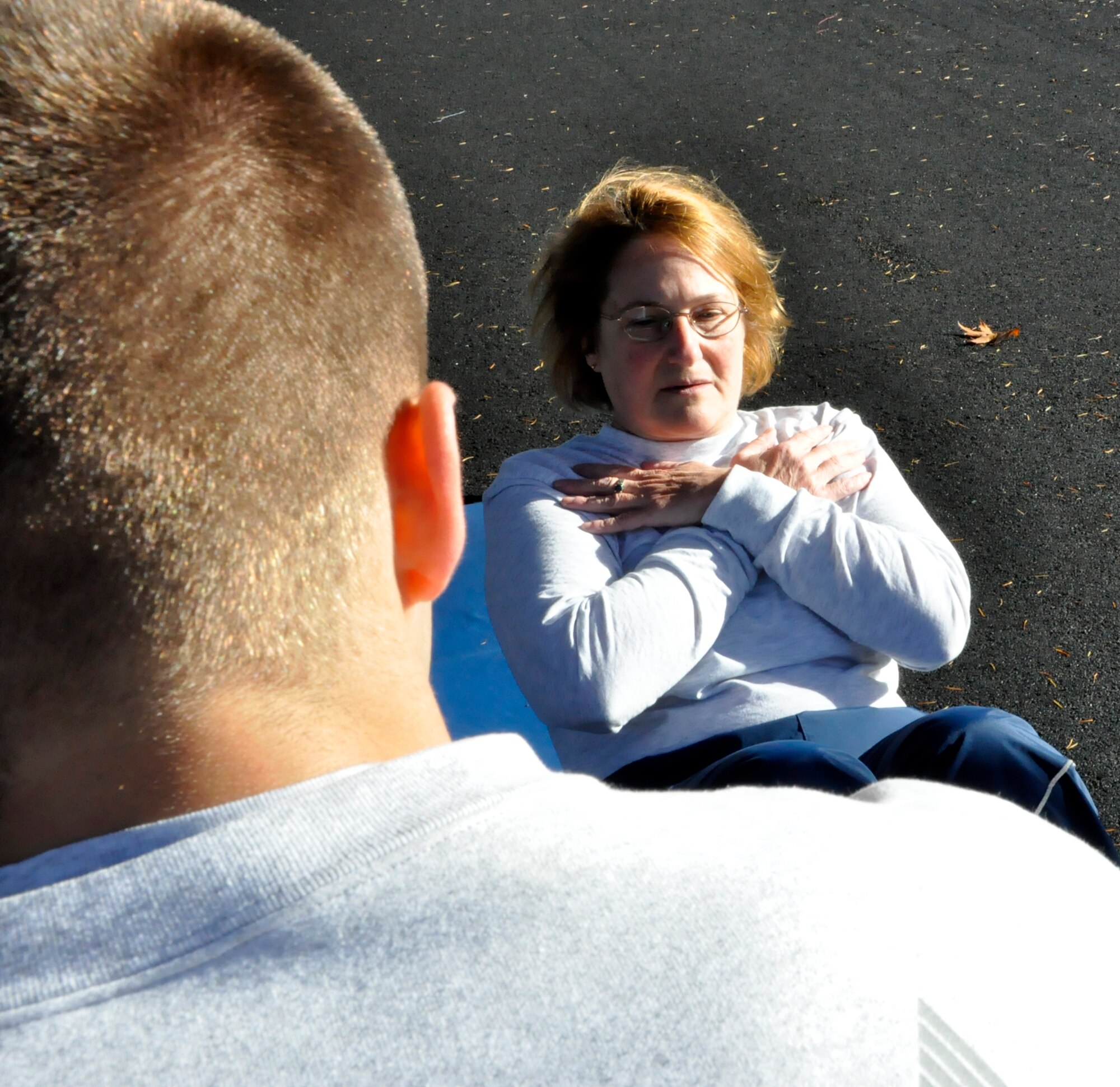 Maj. Maryjane Baska, a Reservist with the 446th Aeromedical Squadron, does the sit-up portion of her fitness assessment at McChord Field's track Oct. 16. According the base's Fitness Assessment Cell, airmen should wear layers to their PT test to allow for their body temperature rising after the warm-up exercises. (U.S. Air Force photo/Staff Sgt. Rachael Garneau)