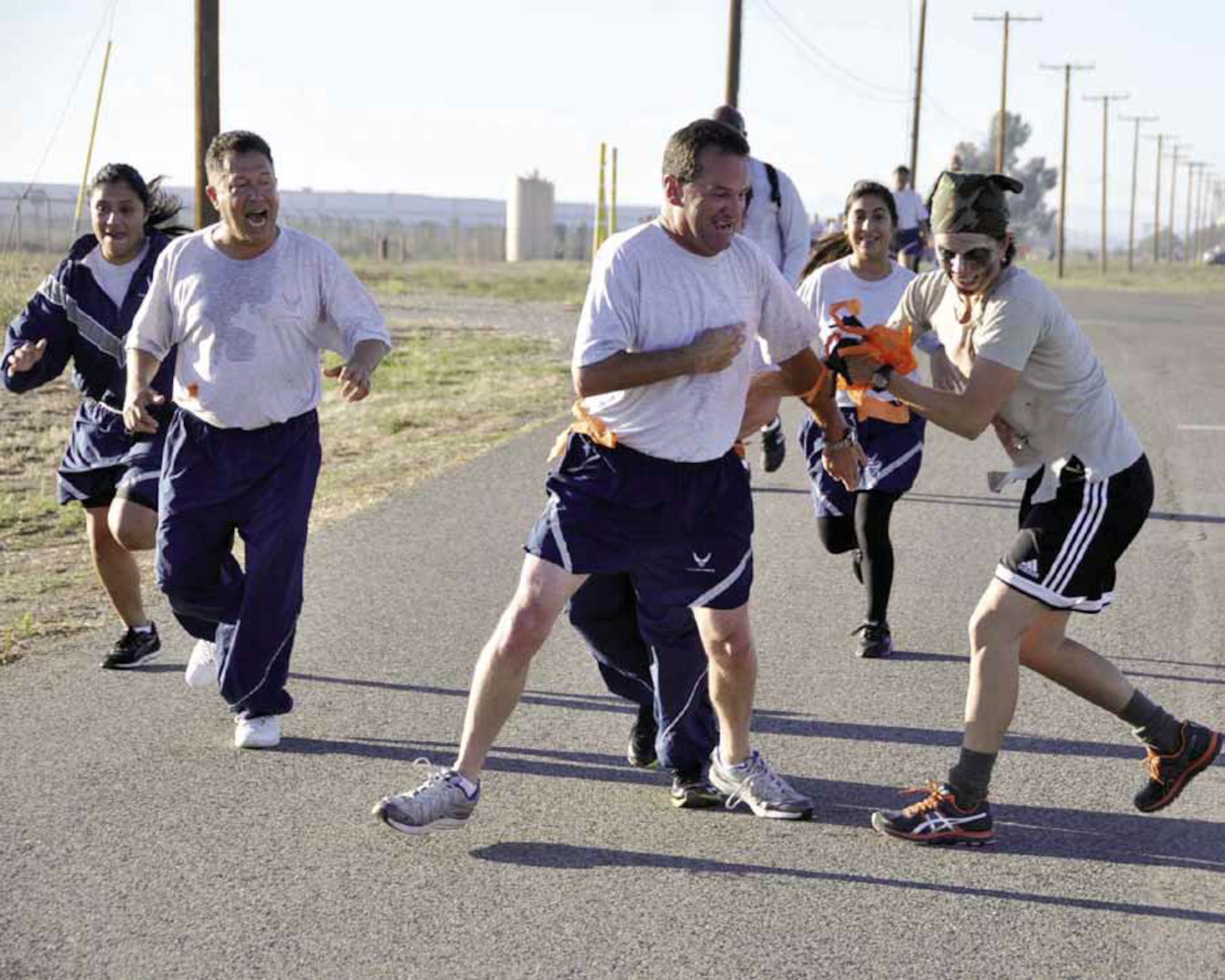 Zombie, Tech. Sgt. Erica Knight, 4th Combat Camera Squadron, attempts to grab a flag from Staff Sgt. Guy La Plante, 4CTCS, during the first March 5K Zombie Run Oct. 14. The 452nd Rising Six organization hosted the run, which they say will become an annual event. (U.S. Air Force photo by Master Sgt. Linda Welz)