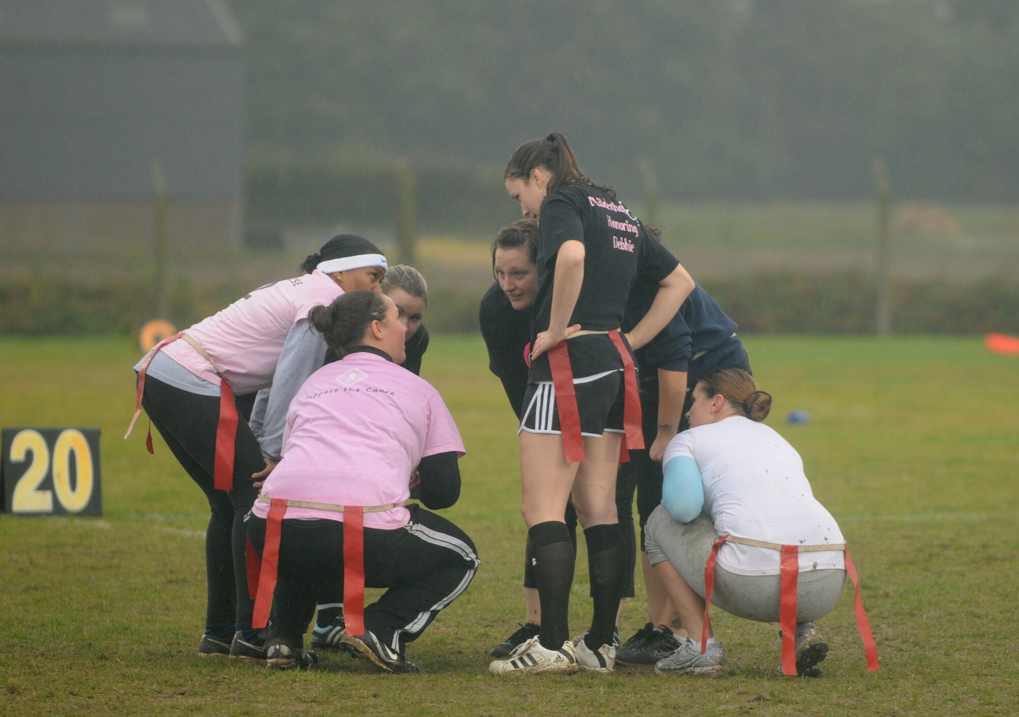 Members of team Triple BBB strategize their next play during the Powder Puff football game Oct. 19, 2012, at RAF Mildenhall, England. The game was hosted by members of the 100th Security Forces Squadron to raise awareness of breast cancer and featured all-female teams. (U.S. Air Force photo by Tech. Sgt. Neal X. Joiner/Released)
