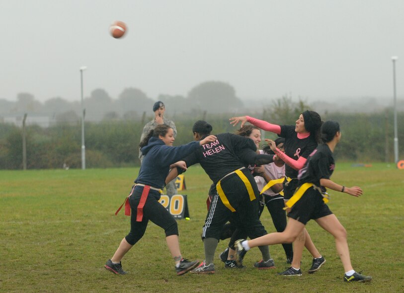 A player passes the ball during the Powder Puff football game Oct. 19, 2012, at RAF Mildenhall, England. The game was hosted by members of the 100th Security Forces Squadron to raise awareness of breast cancer and featured all-female teams. (U.S. Air Force photo by Tech. Sgt. Neal X. Joiner/Released)