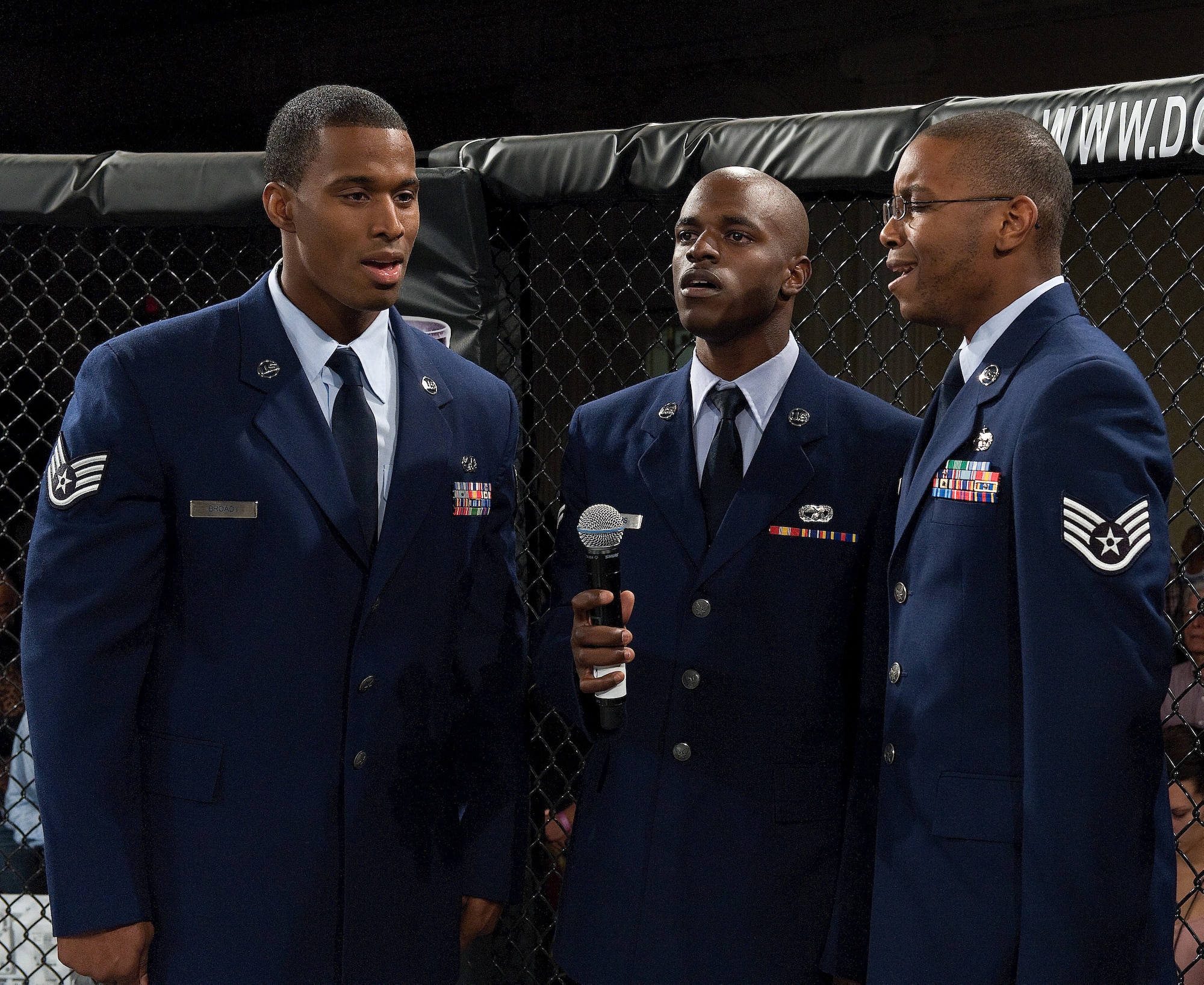 From left to right are Staff Sgt. Ryan Broady, Airman 1st Class Demarrius Jeffers and Staff Sgt. Ntambwe Kambeya singing the national anthem as part of the 512th Airlift Wing's Mass Enlistment Ceremony Oct. 13, 2012, held at a mixed martial arts event in Dover, Del. The trio members are assigned to the 436th Aerial Port Squadron, Dover Air Force Base, Del. (U.S. Air Force photo/Roland Balik)
