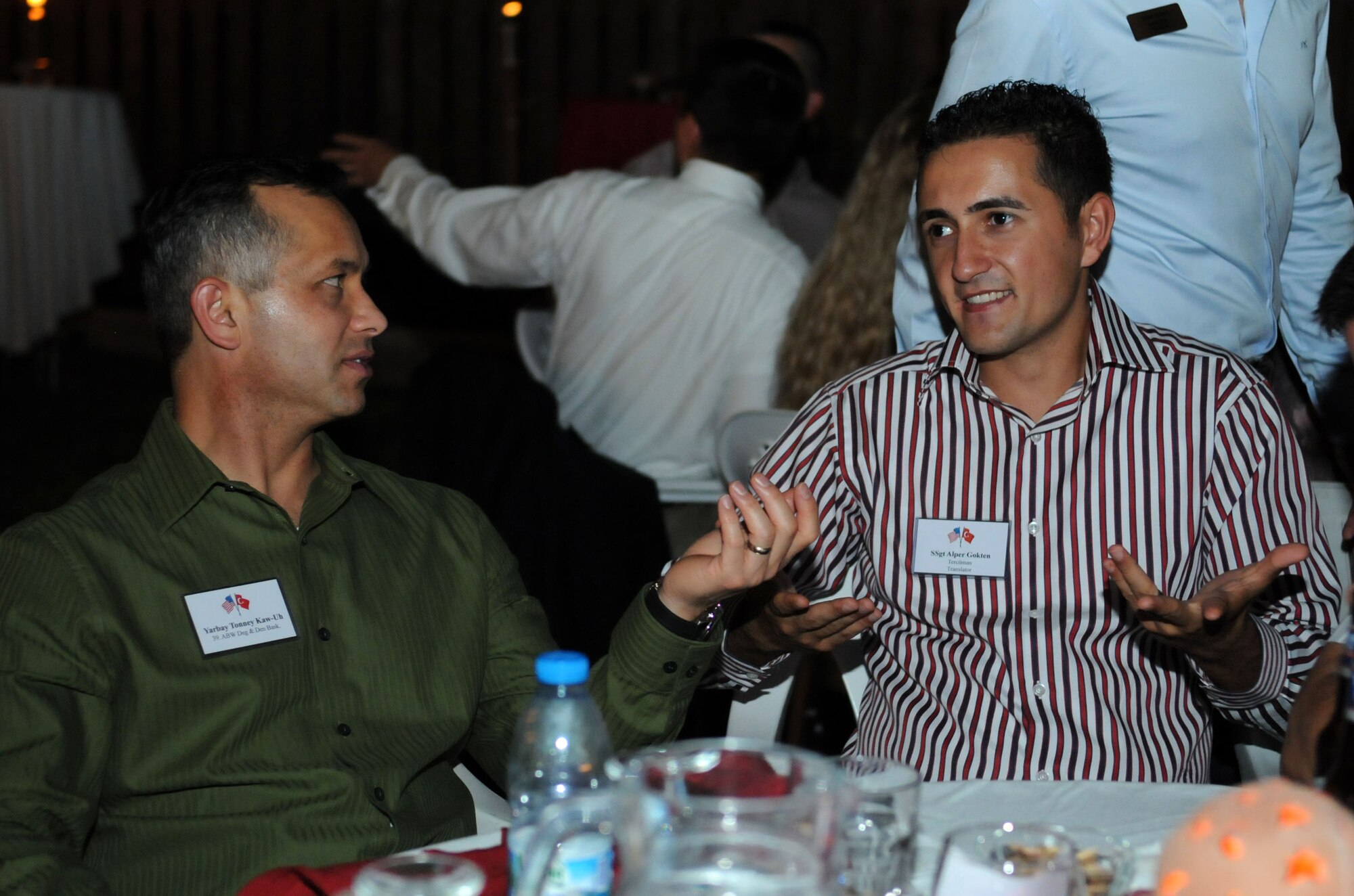 U.S. Air Force Lt. Col. Tonney Kaw-Uh (left) and U.S. Air Force Staff Sgt. Alper Gokten, discuss sports during the Turkish-American Social Sept. 29, 2012, at Incirlik Air Base, Turkey. Members of the 39th Air Base Wing and the Turkish Air Force 10th Tanker Command gathered for a social at the home of Col. Chris Craige, 39th Air Base Wing commander, to relax, mingle and share ideas and stories with each other, which in turn, helps strengthen the partnership between the nations. Kaw-Uh is the 39th ABW inspector general and Gokten is a 39th Logistics Readiness Squadron supply technician. (U.S. Air Force photo by Senior Airman Marissa Tucker/Released)   