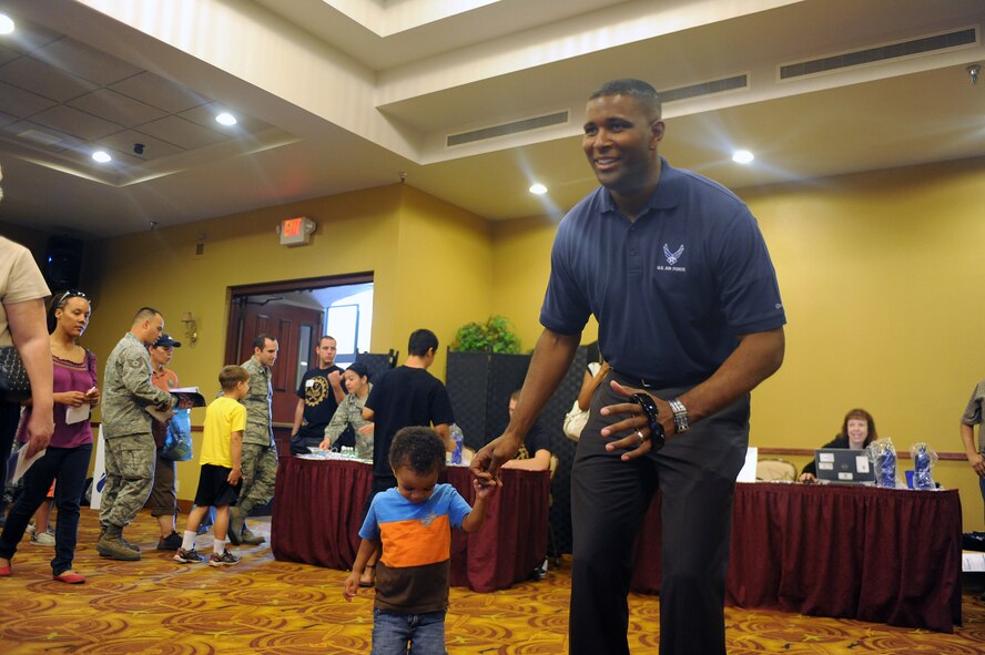 Chaplain (Capt.) Karlton Edison, 56th Fighter Wing chaplain, and his son, Korey, 3, play with the Xbox Kinect during the Men’s Health Expo. The Best Buy booth offered a demo of the Xbox Kinect for attendees and offered information on applications to manage health. (U.S. Air Force photo by Airman 1st Class Devante Williams)