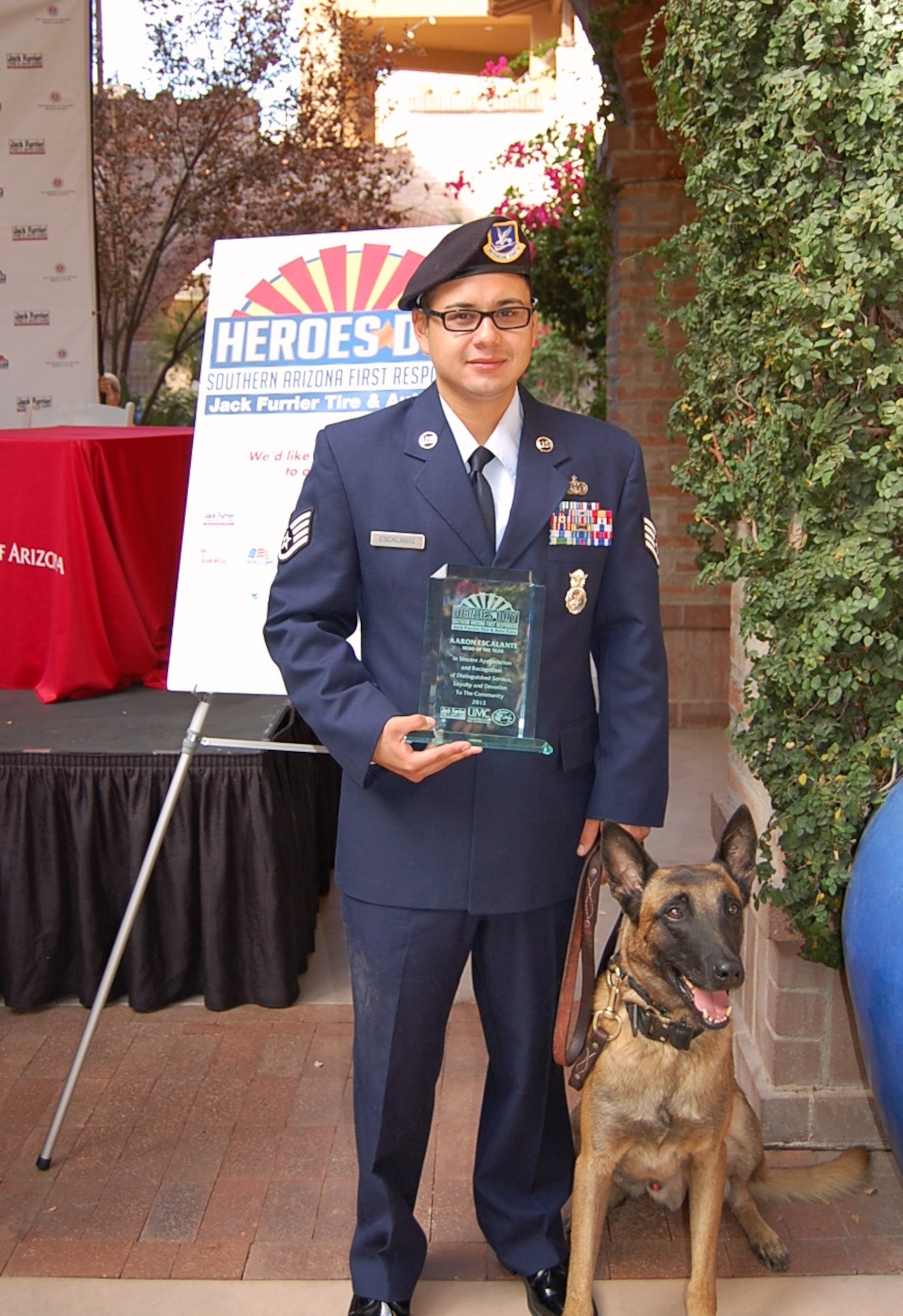Staff Sgt Aaron Escalante, 355th Security Forces Squadron military working dog handler, and Mushe, 355th SFS military working dog, stand together after recieving the Hero of the Year award from the city of Tucson. Sergeant Escalante and Mushe were honored by the city of Tucson for heroic work during their deployment. (U.S. Air Froce photo by 2LT Sarah Ruckriegle/released)