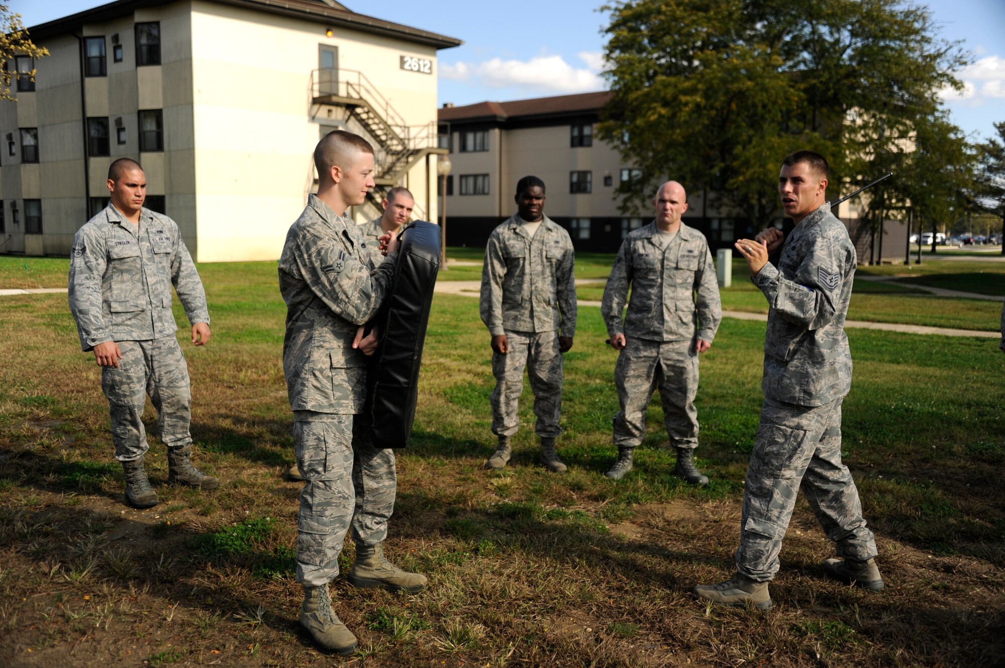 Tech Sgt. James Chubb, 87th security forces squadron NCO in charge of training, exhibits proper use of the non-lethal, collapsible baton while Airman 1st Class Brandyn Davis, 305th Aircraft Maintenance Squadron crew chief, holds the bag during the baton training at the First Term Airman Center here. This FTAC class is the first one to be given an additional two days of training to qualify them as security forces augmentees. (U.S. Air Force photo by Airman Sean Crowe/released)