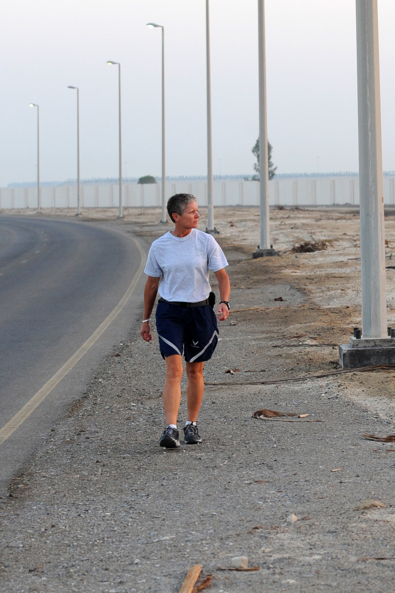 SOUTHWEST ASIA - U.S. Air Force Master Sgt. Laurie Cherry, 727th Expeditionary Air Control Squadron first sergeant, walks along the side of the road at the 380th Air Expeditionary Wing Oct. 17, 2012. Cherry is training for the Susan G. Komen three-day walk for breast cancer research and awareness Nov. 9-11.  (U.S. Air Force photo/Master Sgt. Scott MacKay)