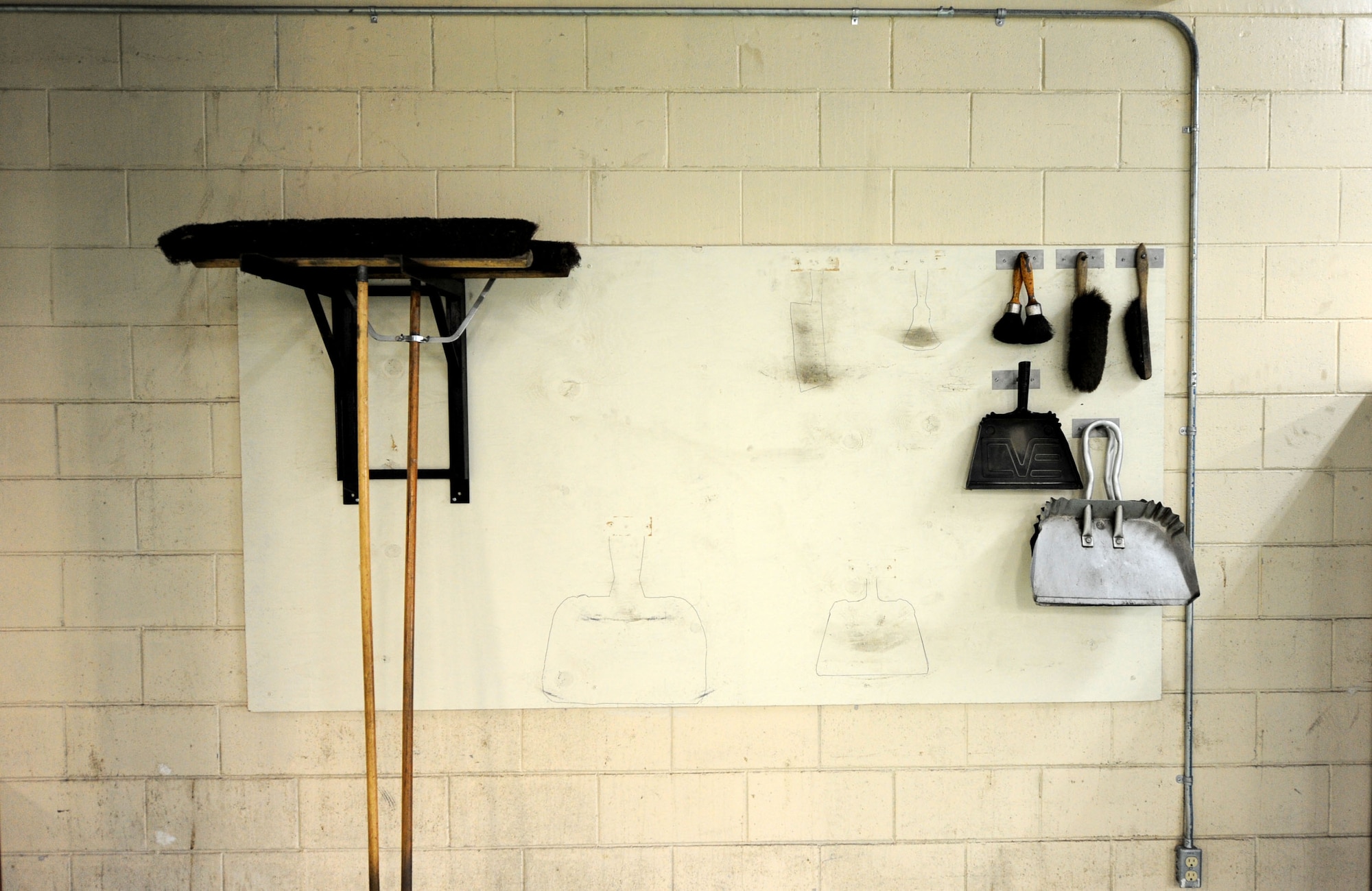Brooms and dust pans hang organized in the 18th Equipment Maintenance Squadron metals shop on Kadena Air Base, Japan, Oct. 18, 2012. With pieces of metal being chipped off daily, it's important to keep the shop clean and organized.  (U.S. Air Force photo/ Airman 1st Class Brooke P. Beers)