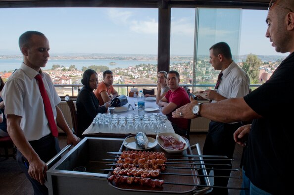 Ahmet Kocacay, 39th Force Support Squadron, translates various menu items for waiters to Tops in Blue members at a restaurant overlooking the Seyhan Lake Dam in Adana, Turkey, Oct. 14, 2012. The 39th FSS sponsored a special trip for Tops in Blue get a taste of the Adana area. (U.S. Air Force photo by Senior Airman Daniel Phelps/Released)