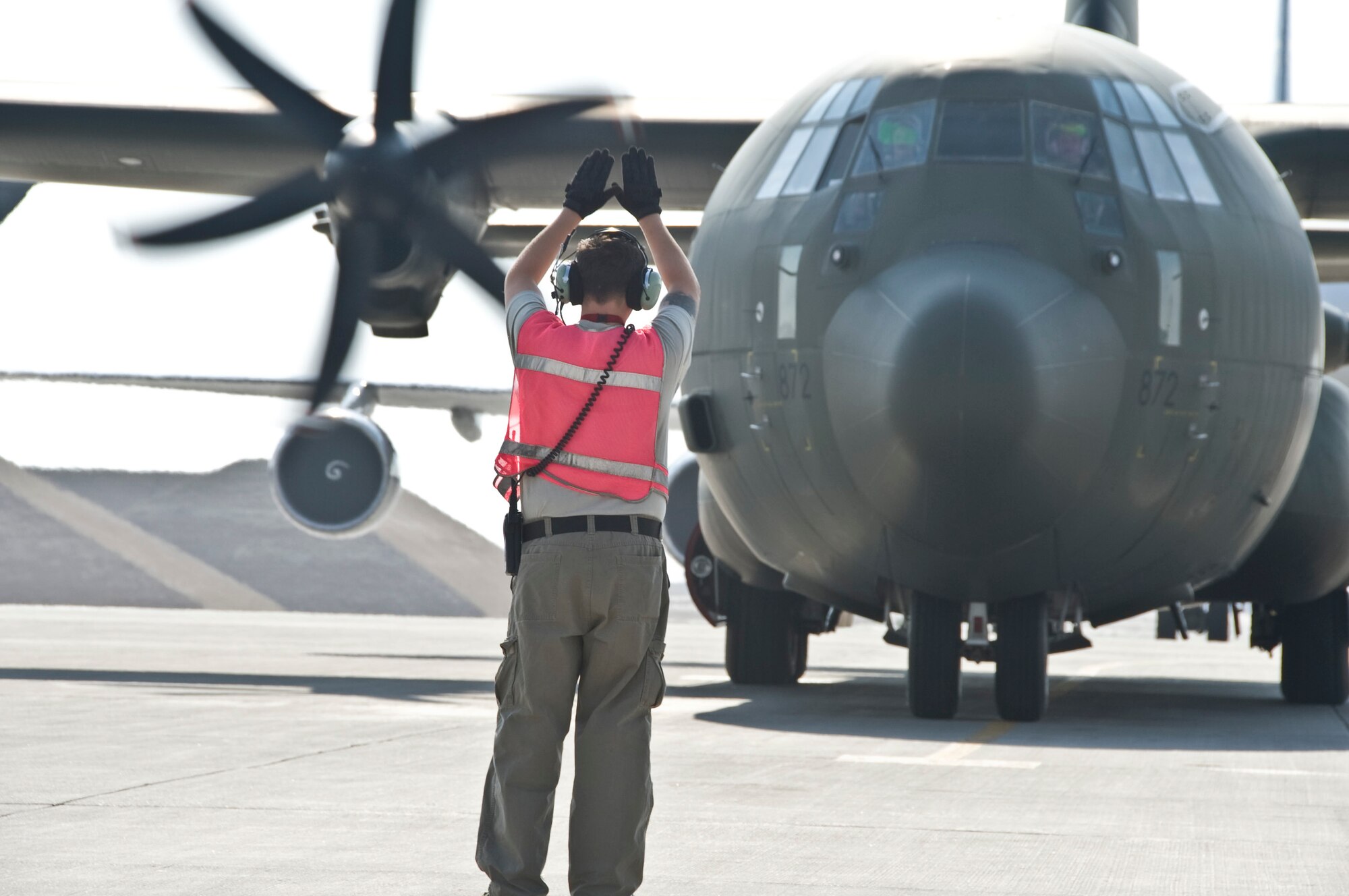 William Brandt, 379th Expeditionary Maintenance Squadron Transient Alert maintenance technician, marshals a Royal Air Force C-130 Hercules into the appropriate parking spot Oct. 11, 2012. Brandt maintains a sharp awareness of his surroundings when maneuvering aircraft around the flightline. This ensures no accidents occur and the aircraft meet the demands of a tight schedule. On average, the Transient Alert team handles between 15 to 20 different aircraft each day totaling more than 500 aircraft each month. (U.S. Air Force photo/Senior Airman Bryan Swink)