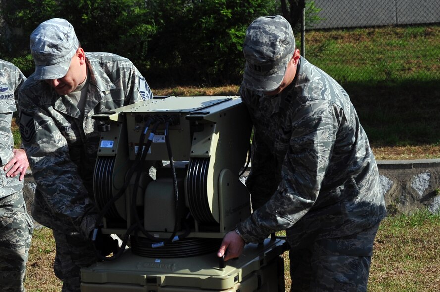 Master Sgt. Bradley Smith, 607th Air Support Operations Group support
flight superintendent, and Capt. Justin Cleveland, 607th ASOG air liaison
officer, begin setup of a very small aperture terminal (VSAT) at Osan Air
Base, Republic of Korea, Oct. 15, 2012. Members from the 607th were training
to setup their communication equipment in a field environment in preparation
of an upcoming peninsula exercise. (U.S. Air Force photo/Staff Sgt. Craig
Cisek)
