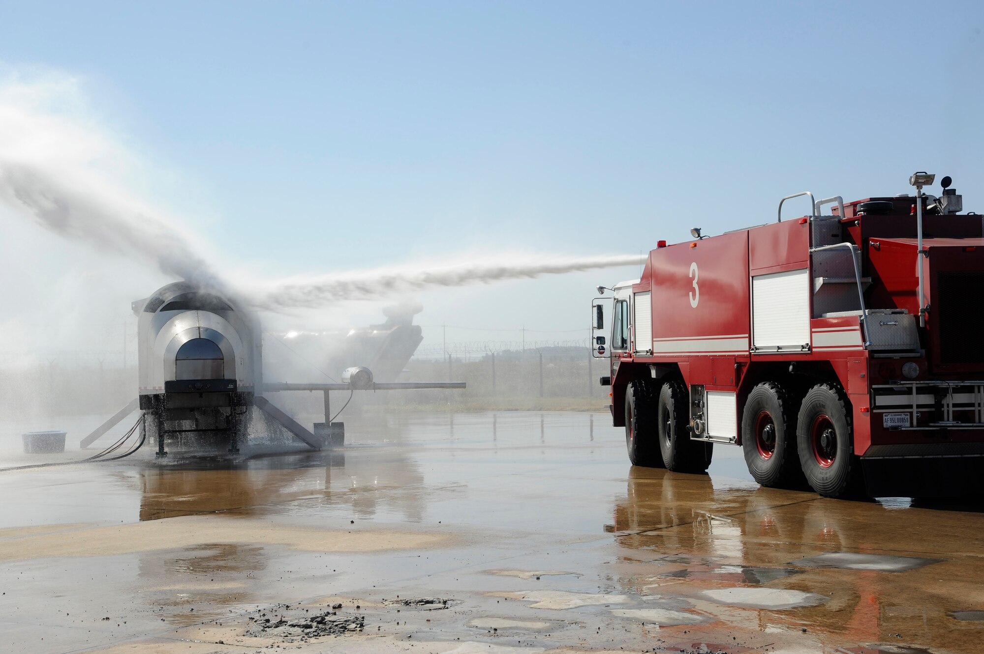Members from the U.S. Air Force 8th Civil Engineer Squadron and Republic of Korea Air Force 38th Fighter Group firefighters practice putting out fires on an aircraft trainer at Kunsan Air Base, Republic of Korea, Oct. 16, 2012. Both forces worked on aiming the boom at the fire and where to drive the crash response vehicle to effectively fight the fire. (U.S. Air Force photo/Senior Airman Marcus Morris)