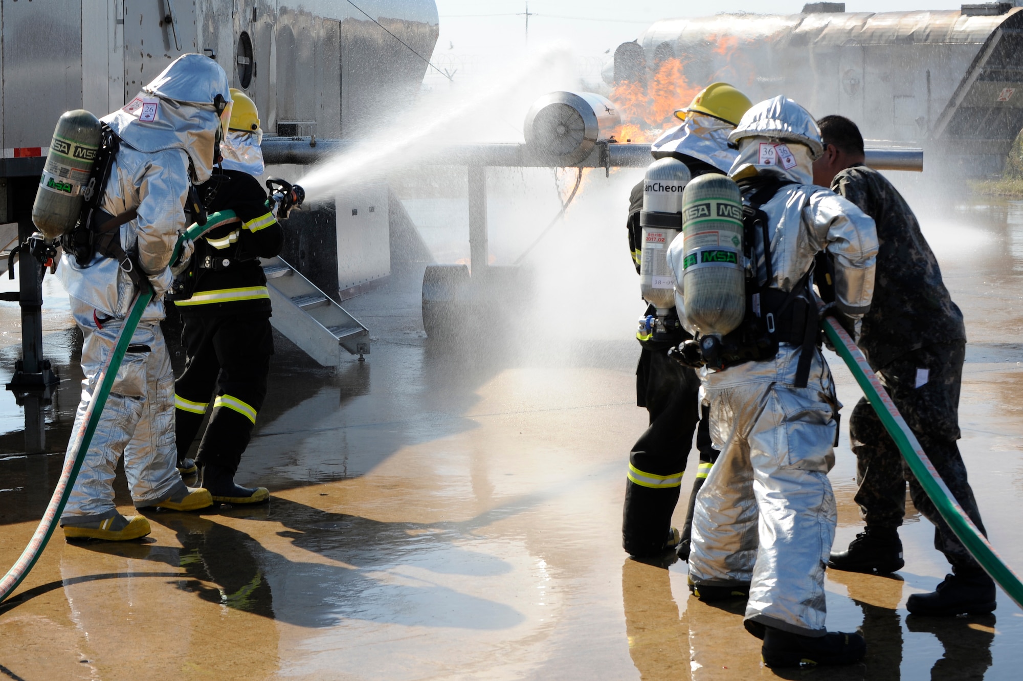Members from the U.S. Air Force 8th Civil Engineer Squadron and Republic of Korea Air Force 38th Fighter Group firefighters put out a fire on an aircraft trainer at Kunsan Air Base, Republic of Korea, Oct. 16, 2012. This was the first time  USAF and ROKAF worked together during their firefighter training. (U.S. Air Force photo/Senior Airman Marcus Morris)