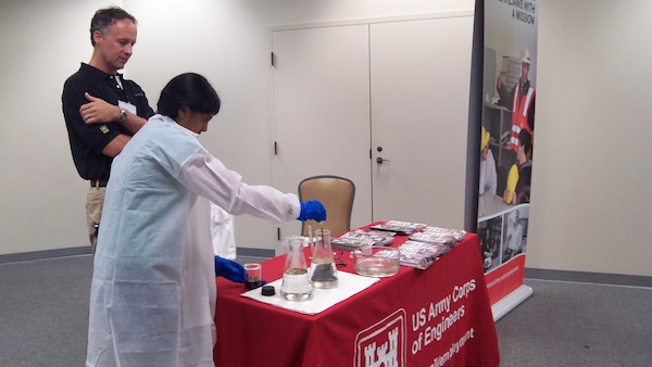 Dr. Karl Gustavson, Engineer Research and Development Center, looks on as a student conducts an experiment to show the effects of oil spill dispersants on surface oil and tools used by ERDC to assess the environmental effects of the oil.