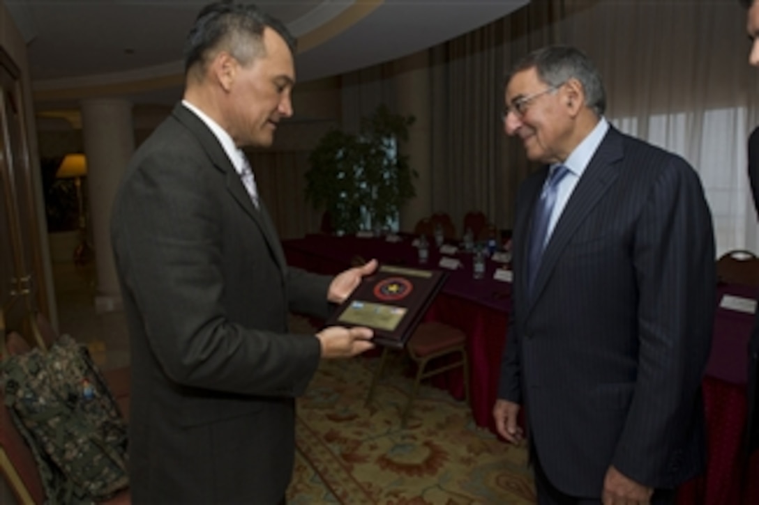 El Salvadorian Minister of Defense Jose Atilio Benitez Parada, left, presents a plaque to Secretary of Defense Leon E. Panetta during a meeting in Punta del Este, Uruguay, on Oct 7, 2012.  Panetta is in Uruguay to attend the 10th Conference of Defense Ministers of the Americas as part of a four-day trip to strengthen defense relationships with Western Hemisphere counterparts.  