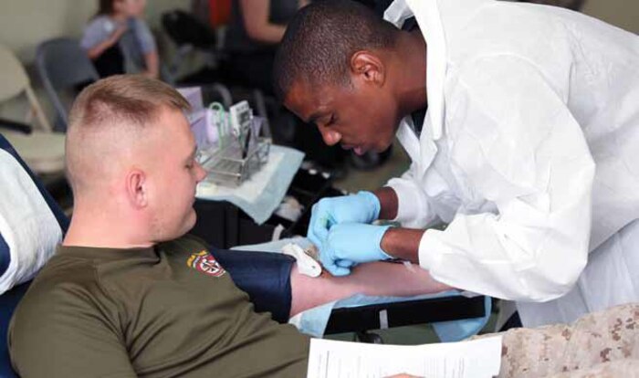 Cpl. Patrick B. Simmerman, left, watches while Seaman Keith Williams inserts a needle into Simmerman’s arm during the 3rd Maintenance Battalion blood drive at Camp Kinser Oct. 16. The battalion hosted the blood drive to help
replenish the Armed Services Blood Bank Center at U.S. Naval Hospital Okinawa. The drive was open to all status of forces agreement individuals. Simmerman is an assault amphibious
vehicle repairer and technician with the battalion. Williams is a hospital corpsman with the Armed Services Blood Bank Center. 3rd Maintenance Bn. is part of Combat Logistics Regiment 35, 3rd Marine Logistics Group, III
Marine Expeditionary Force.
