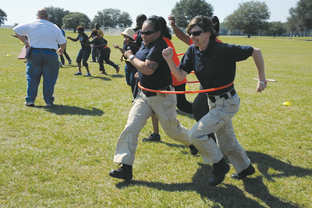 Tonette Gezzi and Angela Dunwoodie, members of the Civilian Police Working Dogs Section, race to the finish line during a hula hoop relay at Marine Corps Logistics Base Albany’s Employee Recognition Day, Oct. 11.