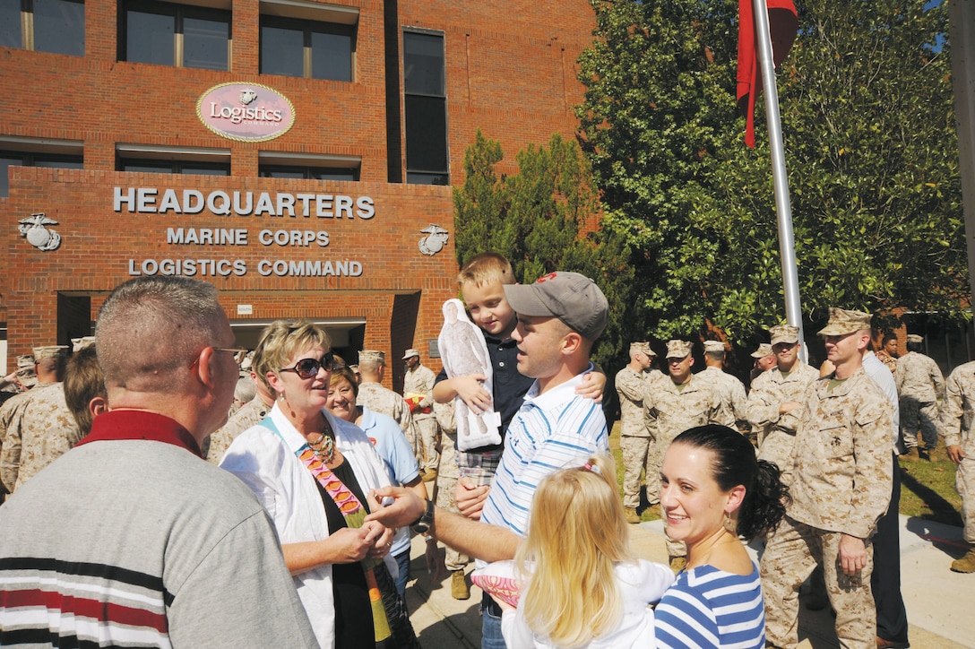 Maj. David Weaver, left, and Capt. Jeffrey Cisek, right, with Marine Corps Logistics Command (Forward), greet family shortly after arriving home from Afghanistan, Oct. 10. The Marines came home to the arms of loved ones and colleagues in front of Building 3700, Marine Corps Logistics Command’s headquarters. Cpl. Anthony Vagnini and Sgt. Derwent Vaughan of MCLC (Forward) also returned with Weaver and Cisek.