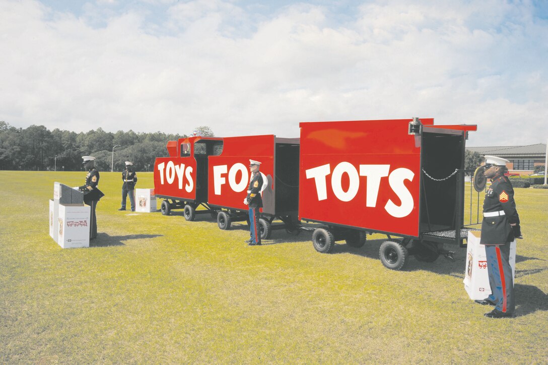 Marines with Detachment 2, Supply Company, 4th Supply Battalion, 4th Marine Logistics Group, stand next to the newly-refurbished Toys for Tots train during their annual Tots for Tots kickoff in front of Building 3500, Monday. They will showcase it at distribution sites and fundraisers throughout the campaign.