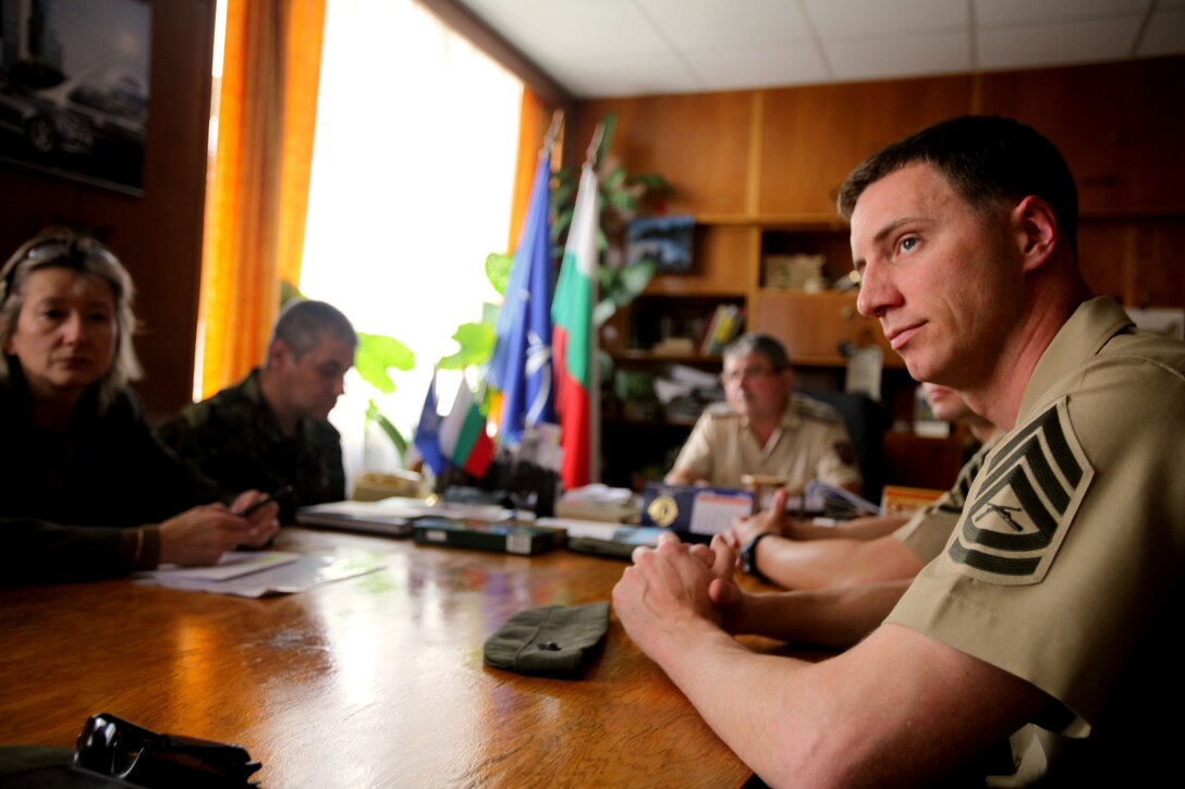 Gunnery Sgt. Joseph Lassendrello, an instructor with noncommissioned officer development team, Command Element, Black Sea Rotational Force 12, listens as the Bulgarian Joint Forces Command Sergeant Major, addresses the Marines prior to beginning a five-day NCO development course, May 15 at Veliko Tarnovo, Bulgaria. The NCO development team is a mobile detachment of instructors tasked with mentoring the NCOs and officers of US partner nations in the fundamentals of leadership, to include: the roles of NCOs and officers, small-unit leadership, decision-making procedures, military professionalism and operational proficiency.