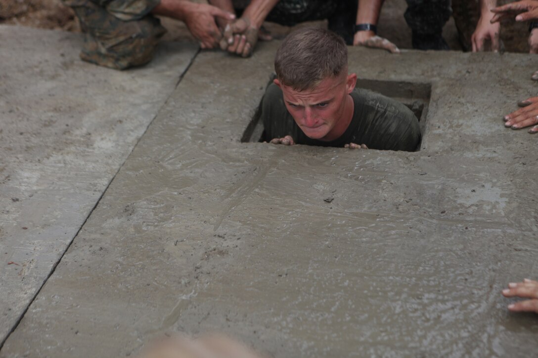 Lance Cpl. Christopher Heatherington, combat engineer with Combat Logistics Battalion 31, 31st Marine Expeditionary Unit and a native of Fairbury, Ill., pushes the top of a concrete septic tank into place during the engineering civil affairs project at the Tagburos Elementary School here, Oct. 16. The ENCAP construction sites took under two weeks, finishing with two closing ceremonies and ribbon cuttings. The ENCAPs is one of multiple humanitarian civil affairs projects conducted by the 31st MEU throughout the island of Palawan during the Amphibious Landing Exercise in the Philippines. PHIBLEX, now in its 29th iteration, is an annually-scheduled exercise between the U.S. and Philippine forces, aimed at strengthening military-to-military interoperability and bilateral relationships.