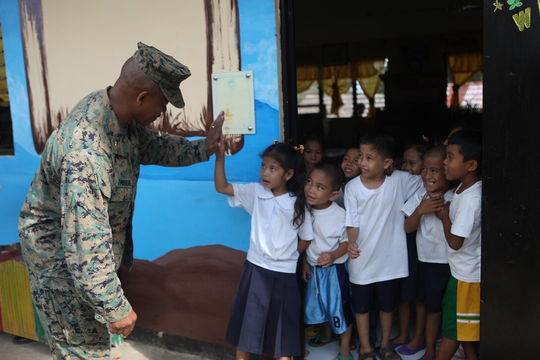 Brigadier Gen. Craig Timberlake, commanding general of the 3rd Marine Expeditionary Brigade, interacts with the local Filipino school children of the Santa Cruz ELementary School during the engineering civil affairs project here, Oct. 15. Timberlake visited various current and previous ENCAP sites during the 31st MEUs projects in Palawan to oversee the progress and visit the local Filipinos who benefit fromthe projects. The ENCAPs are one of multiple humanitarian civil affairs projects conducted by the 31st MEU throughout the island of Palawan during the Amphibious Landing Exercise in the Philippines. PHIBLEX, now in its 29th iteration, is an annually-scheduled exercise between the U.S. and Philippine forces, aimed at strengthening military-to-military interoperability and bilateral relationships.