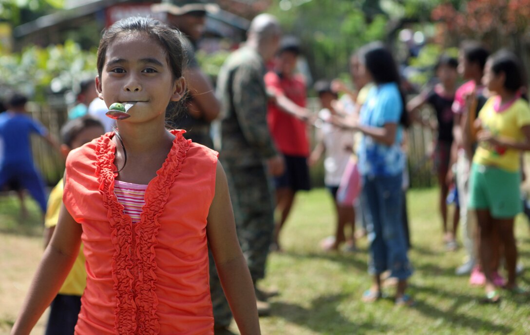 A Filipino elementary school child runs a spoon race with U.S. Marines and Sailors of the 31st Marine Expeditionary Unit at the Santa Fe Elementary School during one of the four community relations projects here, Oct. 15. One of four COMREL visits scheduled during the MEU's Amphibious Landing Exercise throughout the Philippines, Marines and Sailors visit multiple elementary schools in Puerto Princesa City to play with the children before rendering medical and dental care and engineering assistance. PHIBLEX, now in its 29th iteration, is an annually-scheduled exercise between the U.S. and Philippine forces, aimed at strengthening military-to-military interoperability and bilateral relationships.