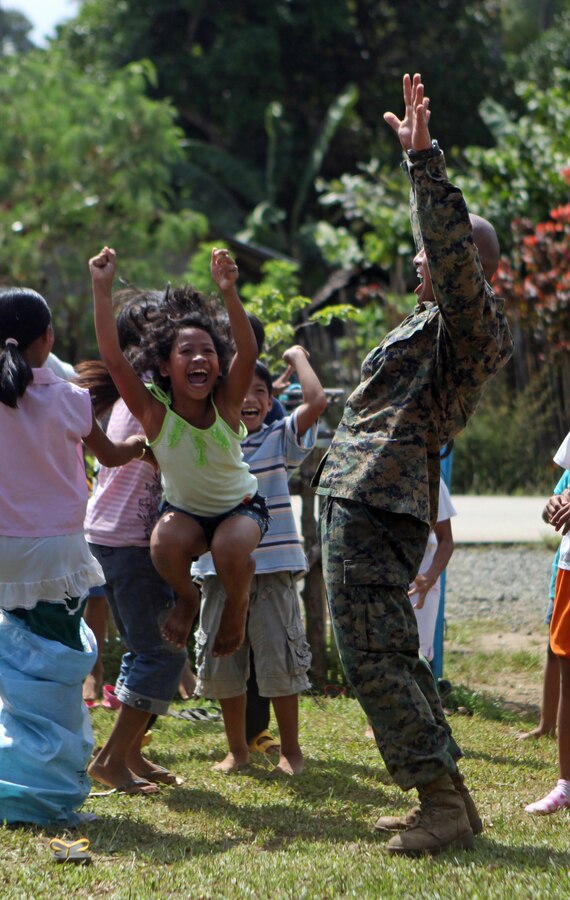 Gunnery Sgt. Cyrus Nator, civil military officer for the 31st Marine Expeditionary Unit and native of Naga City, Camarines Sur, Republic of the Philippines, celebrates with local Filipino children at the Santa Fe Elementary School during one of the four community relations projects here, Oct. 6. The COMREL projects help build new relationships and well as strengthening existing ties with the locals. The COMREL projects are one of multiple humanitarian civil affairs projects conducted by the 31st MEU throughout the island of Palawan during the Amphibious Landing Exercise in the Philippines. PHIBLEX, now in its 29th iteration, is an annually-scheduled exercise between the U.S. and Philippine forces, aimed at strengthening military-to-military interoperability and bilateral relationships.