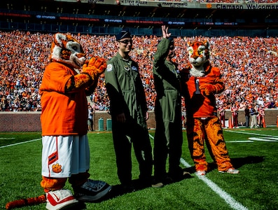 Capt. Justin Kulish (left) and Capt. Michael Polidor (right), B-2 Bomber pilots from Whiteman Air Force Base, Mo., stand with mascots from the Clemson Tigers during a ceremony Oct. 20, 2012, at Memorial Stadium, Clemson S.C. The two pilots were recognized for their efforts providing close-air support during an insurgent ambush of Command Outpost Keating in October 2009. (U.S. Air Force photo/Senior Airman Dennis Sloan) 