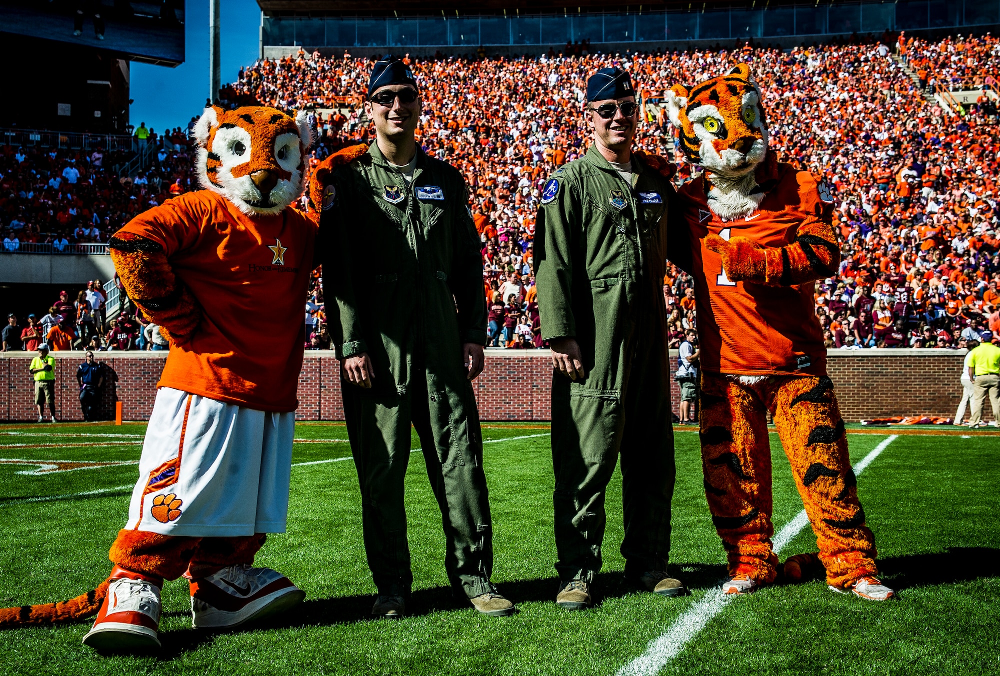 Capt. Justin Kulish (left) and Capt.  Michael Polidor (right), B-2 Bomber pilots from Whiteman Air Force Base, Mo., stand with mascots from the Clemson Tigers during a ceremony Oct. 20, 2012, at Memorial Stadium, Clemson S.C. The two pilots were recognized for their efforts providing close-air support during an insurgent ambush of Command Outpost Keating in October 2009. (U.S. Air Force photo/Senior Airman Dennis Sloan)