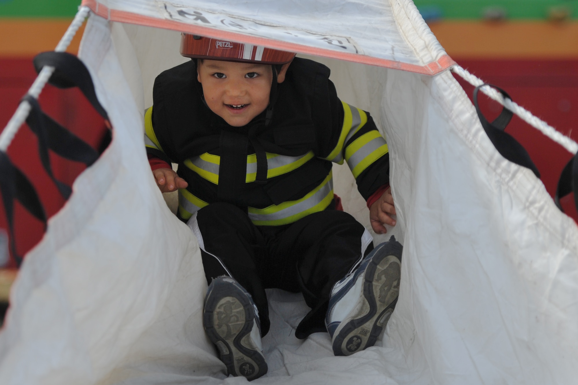 Three-year-old Brandon Luna slides down a fire shoot during Air Power Day 2012 at Osan Air Base, Republic of Korea, Oct. 20, 2012. Air Power Day 2012 represents an annual opportunity for the United States to showcase its military personnel and unique equipment to a global audience.The airshow presents highlights the relationship between the 51st Fighter Wing and the Republic of Korea through public demonstrations of military equipment and personnel. (U.S. Air Force photo/Staff Sgt. Craig Cisek)