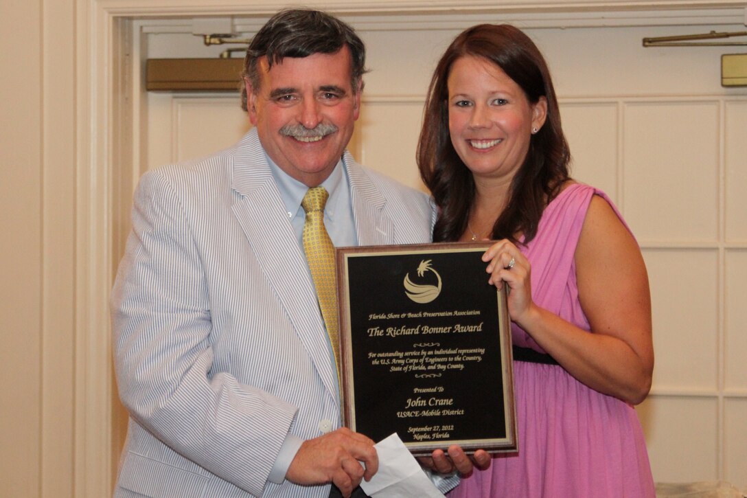 John Crane, a Mobile District project manager, holds the Richard E. Bonner Award with Lisa Armbruster, beach management consultant and government affairs liaison for the Florida Shore & Beach Preservation Association. Photo courtesy of FSBPA.
