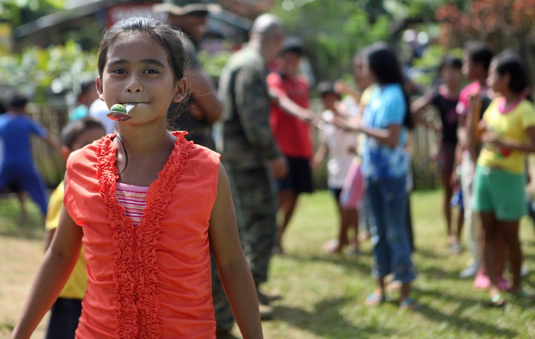 A Filipino elementary school child runs a spoon race with U.S. Marines and Sailors of the 31st Marine Expeditionary Unit at the Santa Fe Elementary School during one of the four community relations projects here, Oct. 15. One of four COMREL visits scheduled during the MEU's Amphibious Landing Exercise throughout the Philippines, Marines and Sailors visit multiple elementary schools in Puerto Princesa City to play with the children before rendering medical and dental care and engineering assistance. PHIBLEX, now in its 29th iteration, is an annually-scheduled exercise between the U.S. and Philippine forces, aimed at strengthening military-to-military interoperability and bilateral relationships.